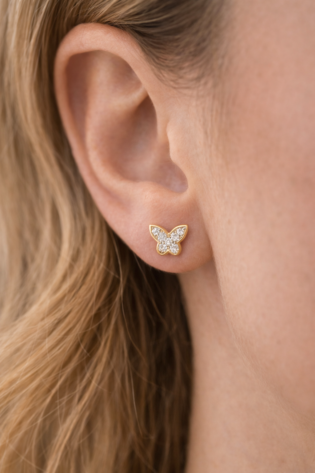 A close up of a young lady's ear wearing Diamond Butterfly Stud Earrings from Brilliant Fine+Custom Jewelry