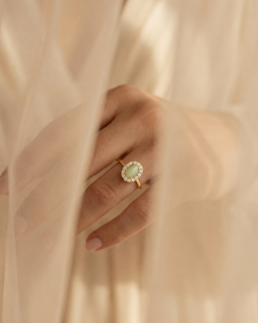 A close up of an heirloom ring with a round opal center stone with diamond halo set in yellow gold from Brilliant Fine+Custom  Jewelry.