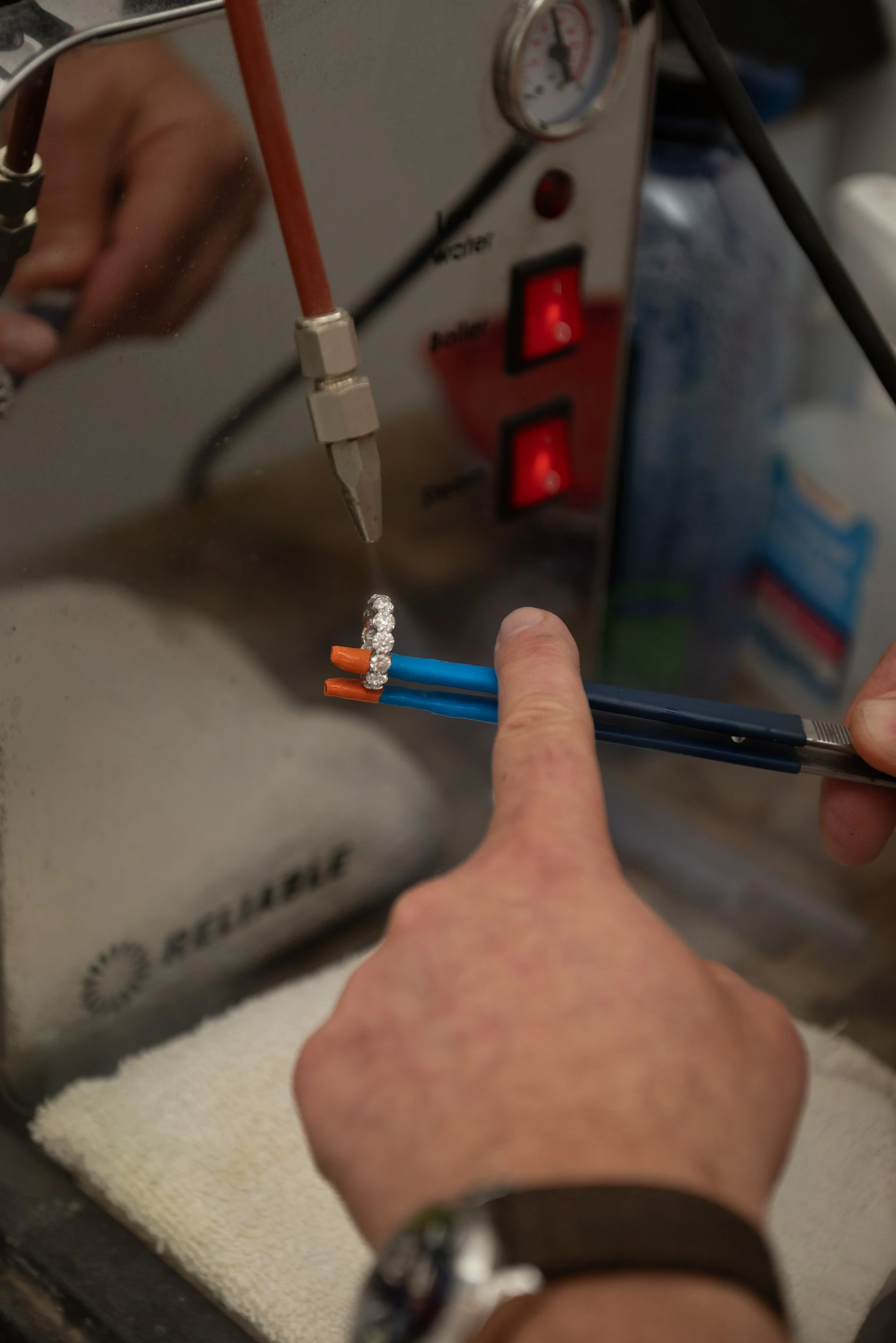 Skilled jeweler Jamie Jaffe sets diamonds in a 10-diamond heirloom band at Brilliant Fine+Custom Jewelry.