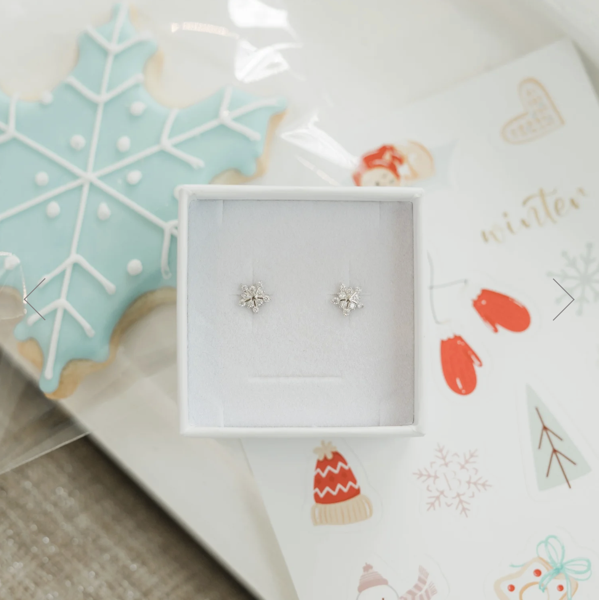 Sterling silver snowflake necklace from the Brilliant Moments Box gift set for kids, shown on a soft holiday flat lay.