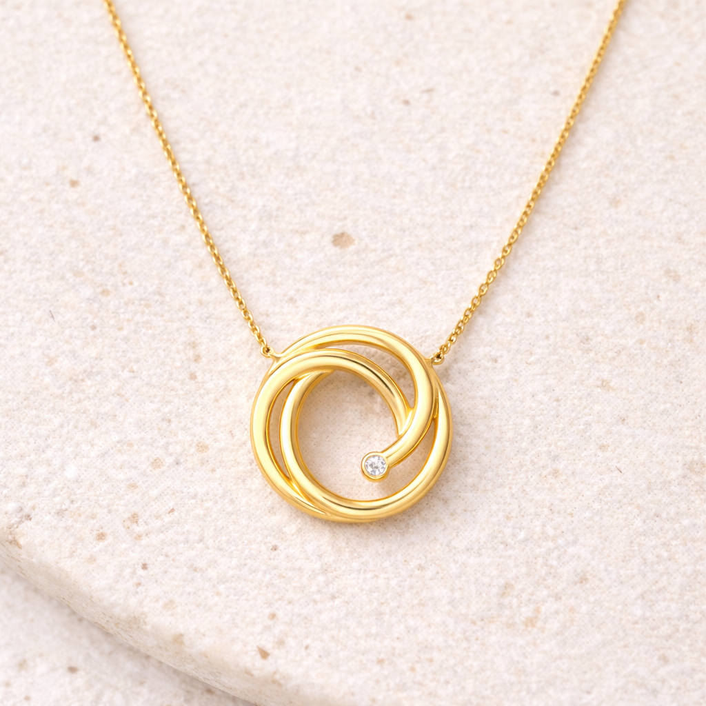 A necklace in 14k yellow gold with a swirl pendant and 0.01 ctw Diamond from Brilliant Fine+Custom Jewelry