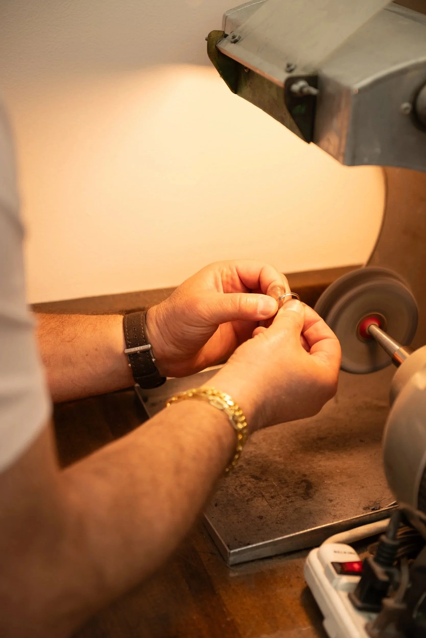 Jeweler polishing a ring by hand at Brilliant Fine + Custom Jewelry in Roswell.