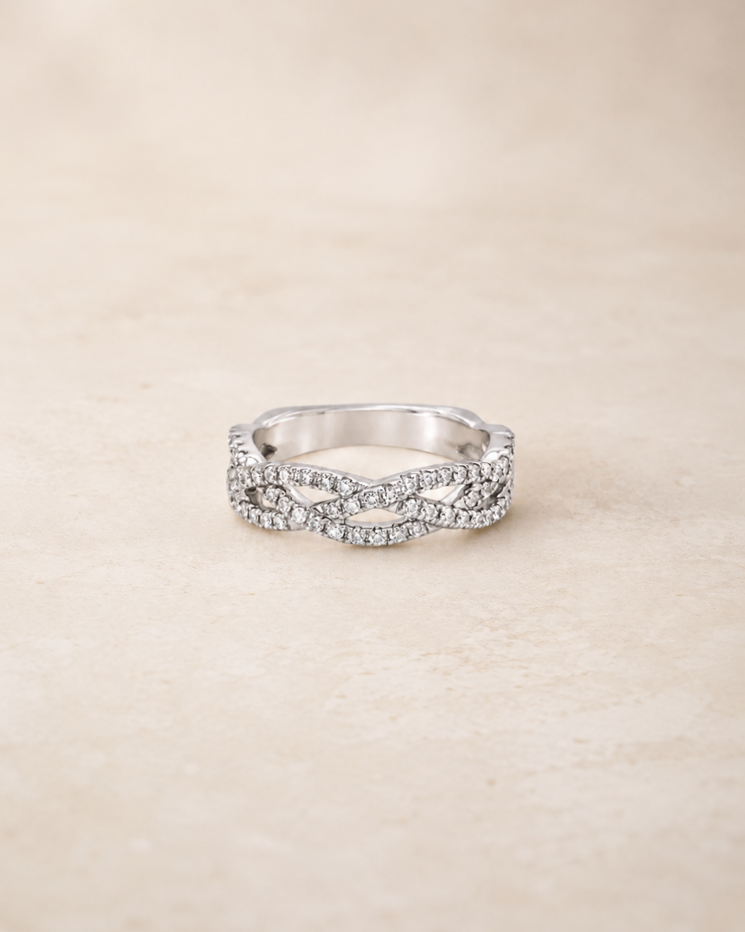 A braided band in white gold with diamond pave, perfect as a milestone ring in a ring stack from Brilliant Fine+Custom Jewelry.