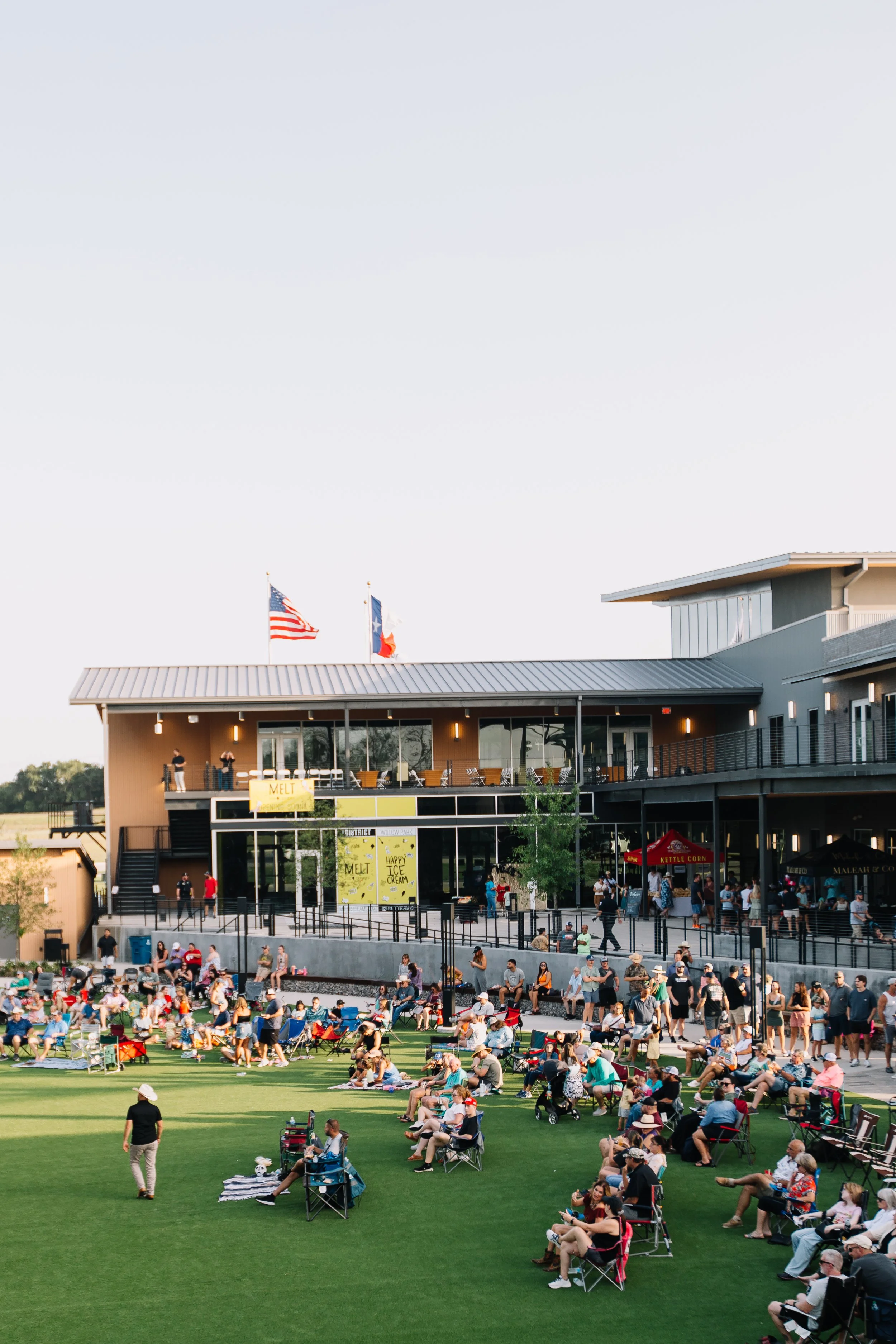 People gathered on the lawn at The District watching a concert