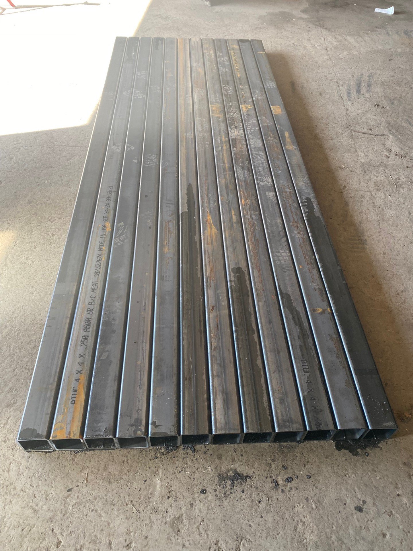 Stack of rectangular steel tubes on a warehouse floor
