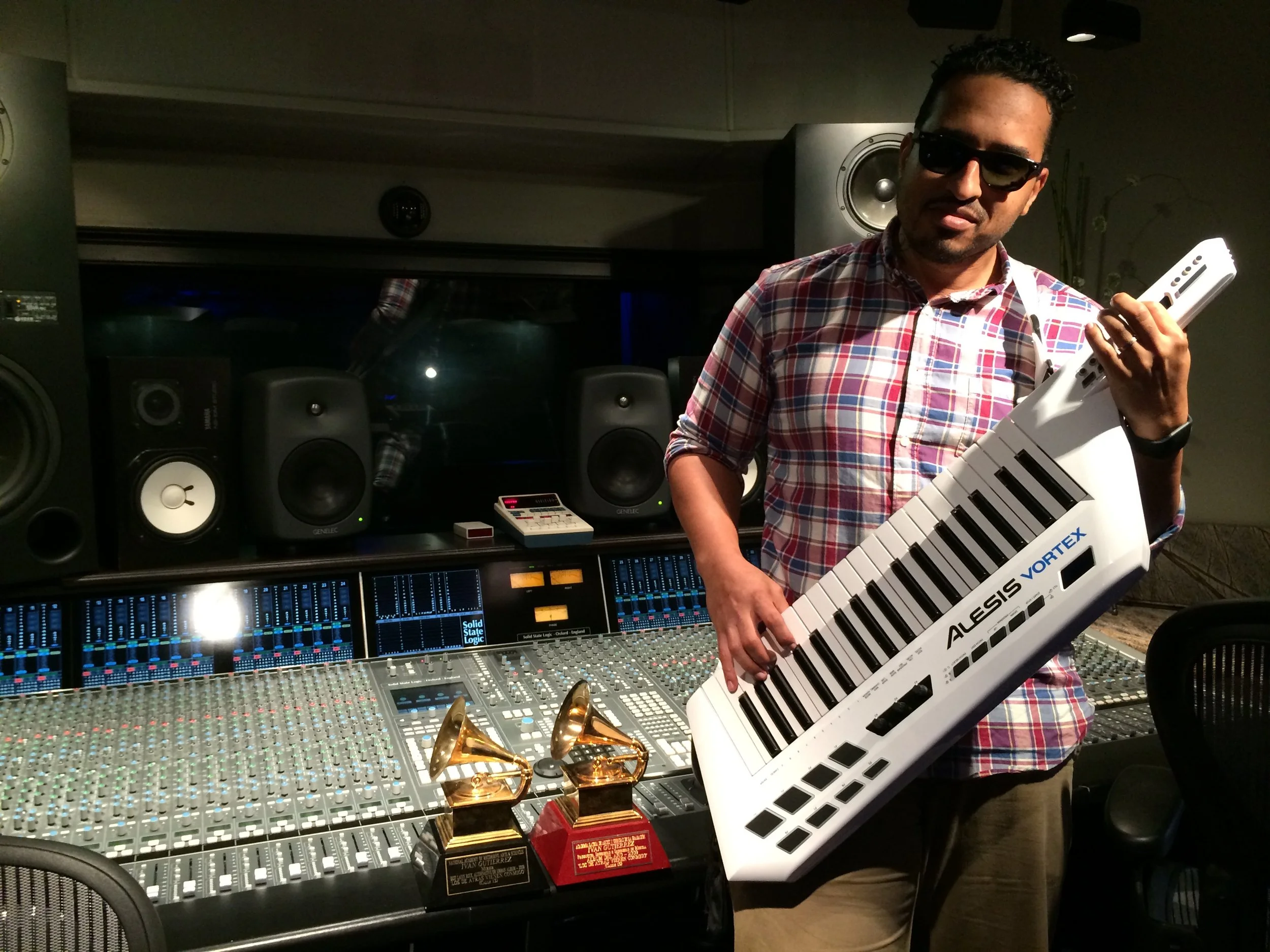 Franklin "Alphabeat" Socorro posing with a Keytar in front of 2 Grammys sitting on Vanquish Studios SSL Duality. 
