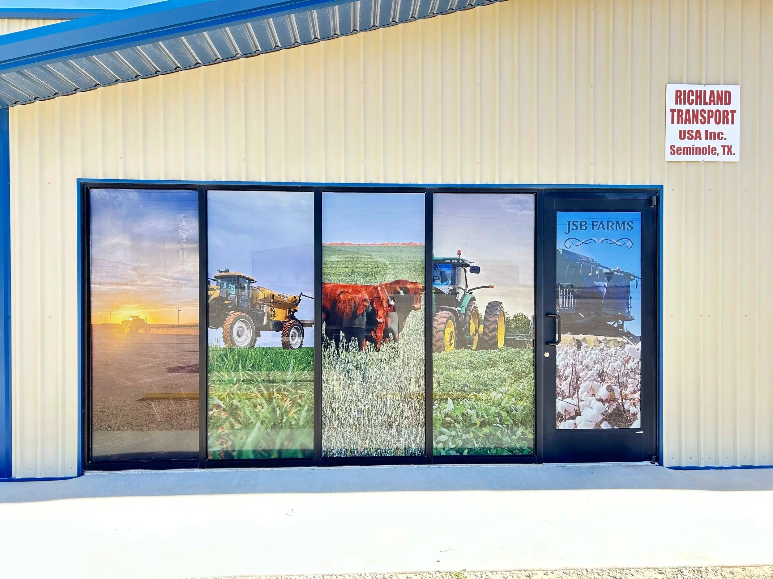 Building with a large window featuring a farm scene mural, including tractors, fields, and crops; sign on wall reads 'Richland Transport USA Inc. Seminole, TX.'.