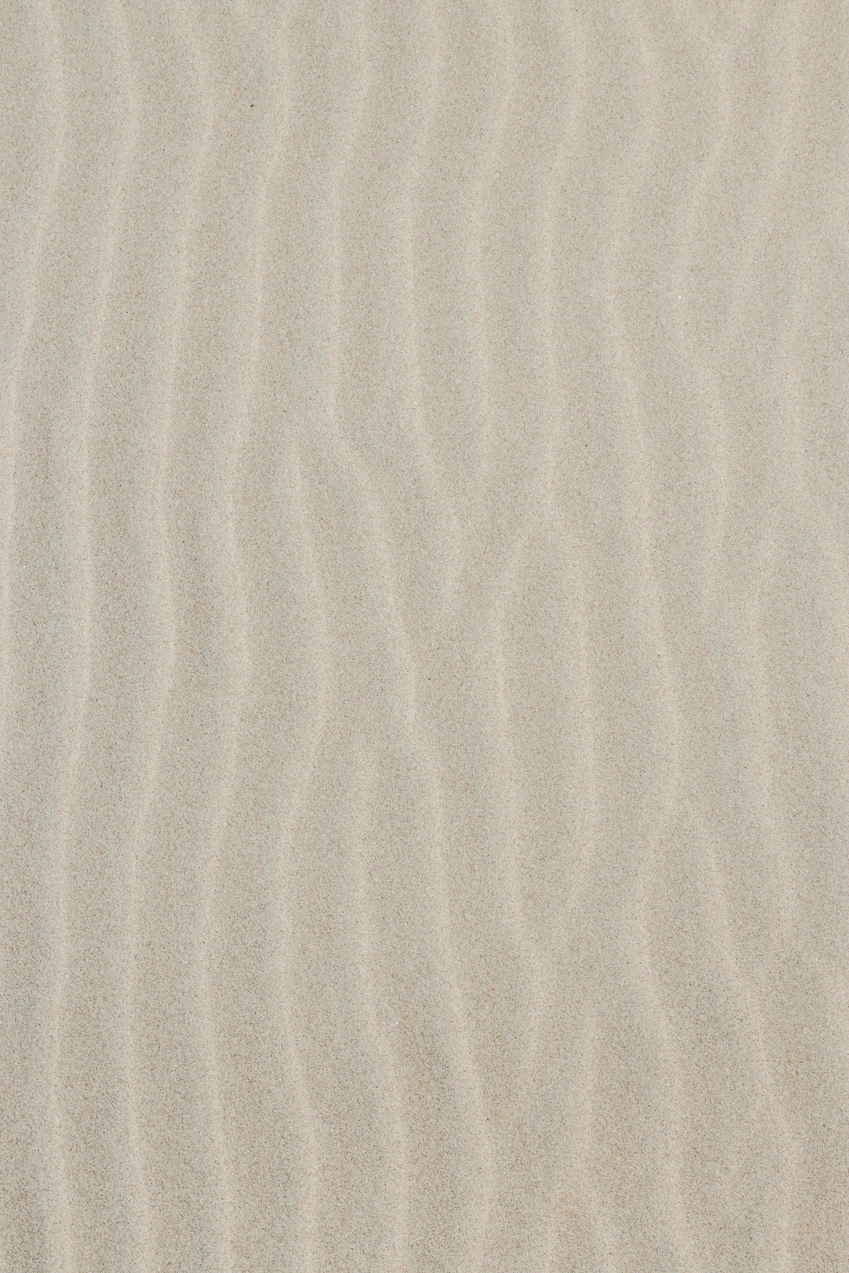 A sandy beach with fine, light-colored sand and no visible objects.