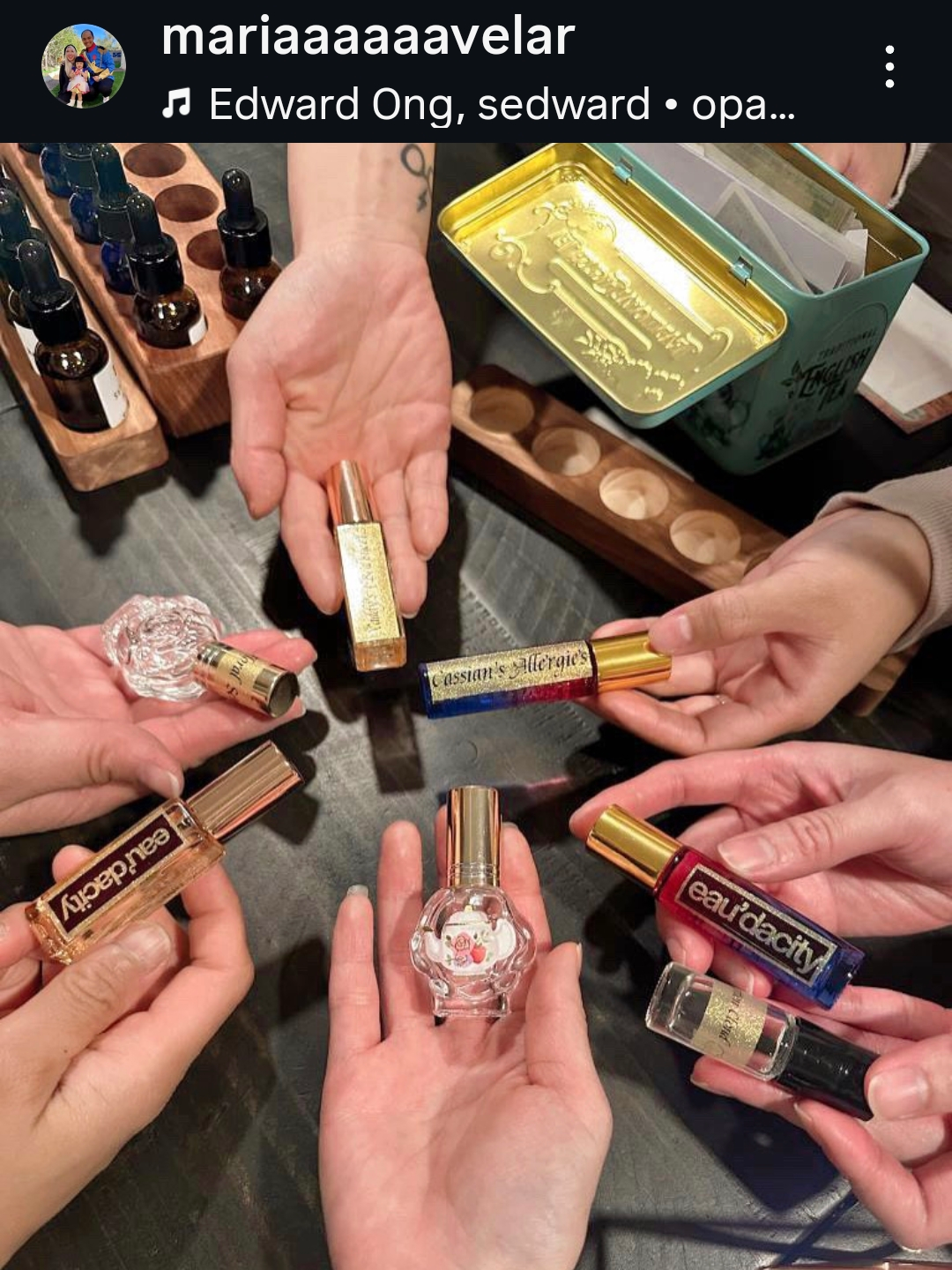 Multiple hands holding small perfume bottles eaudacity homemade diy perfume experience