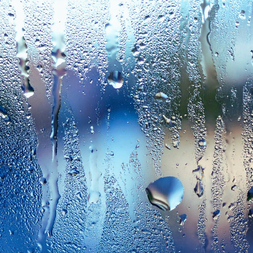 Rain droplets on a glass window with blurred colorful background