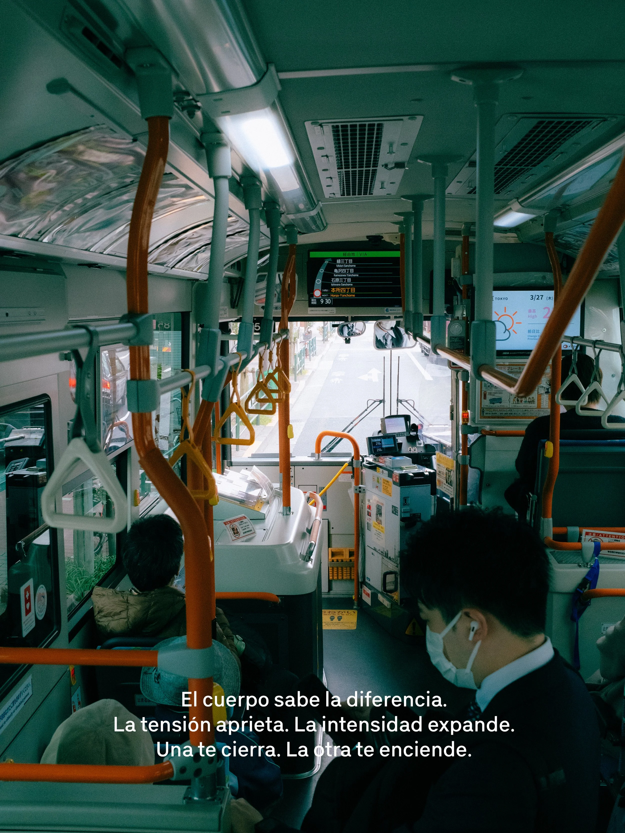Interior de un autobús con pasajeros sentados, algunos con mascarilla, vista hacia la parte delantera y la vía. Pantallas digitales muestran información y clima. Texto en pantalla: "El cuerpo sabe la diferencia. La tensión aprieta. La intensidad expande. Una te cierra. La otra te enciende".