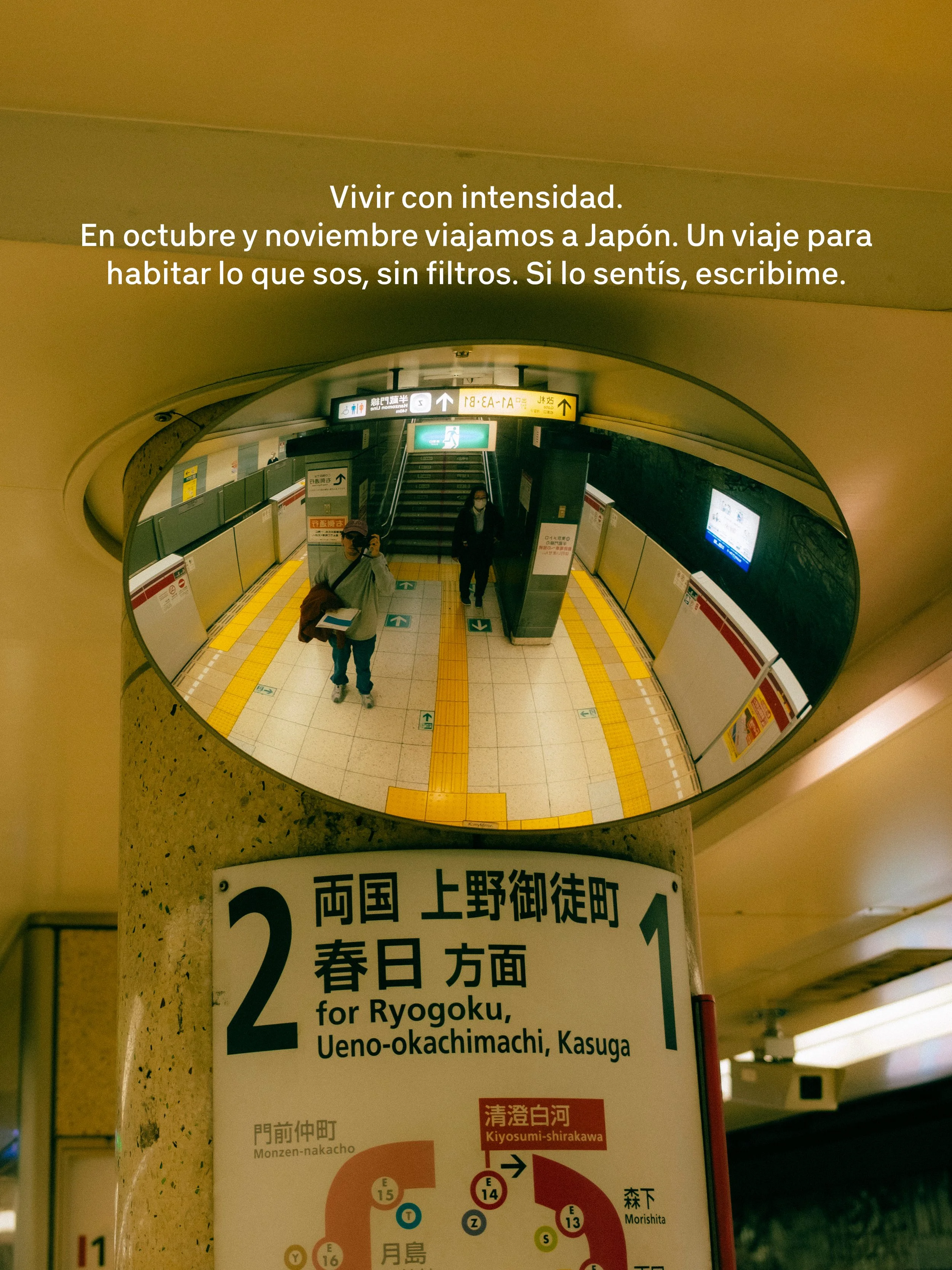 Imagen de una estación de metro en Japón vista desde arriba, con un cartel que indica la dirección hacia Ryogoku, Ueno-okachimachi y Kasuga, y un mapa del sistema de trenes debajo.