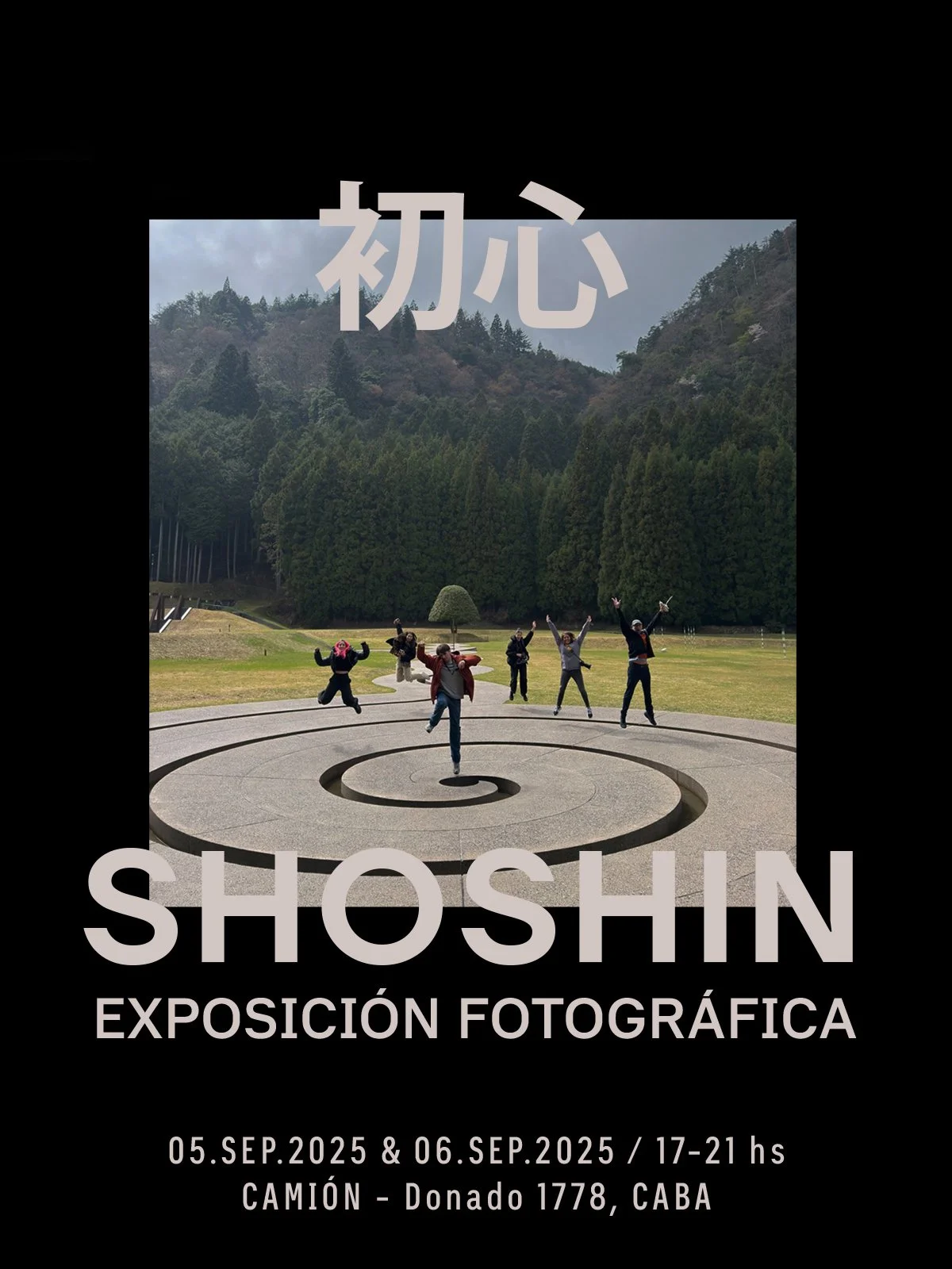 Cartel de exposición fotográfica en parque con un grupo de personas saltando y posando, montañas y árboles al fondo, con el texto en japonés y en español.