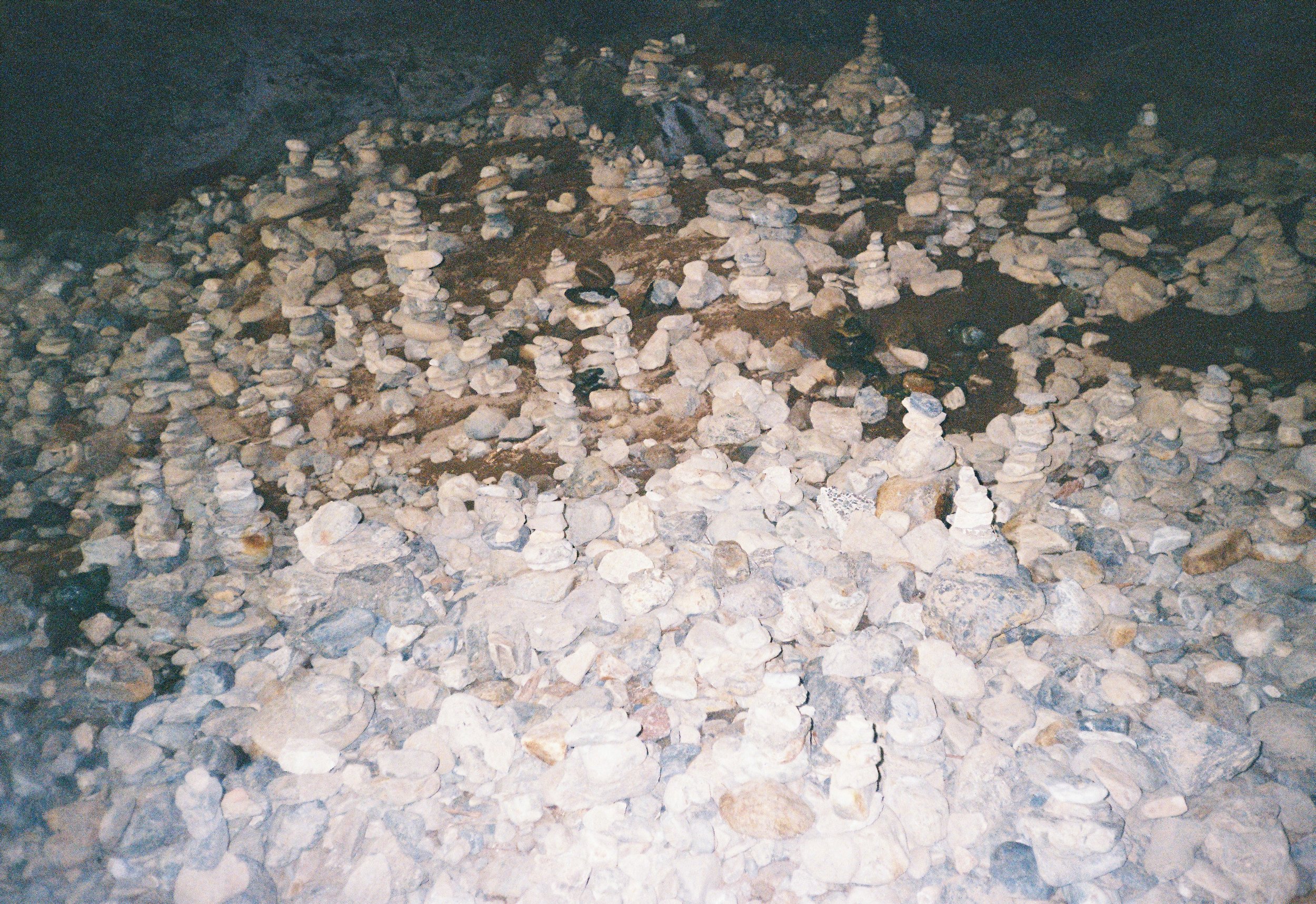 Montones de piedras apiladas en un espacio oscuro y bajo tierra.