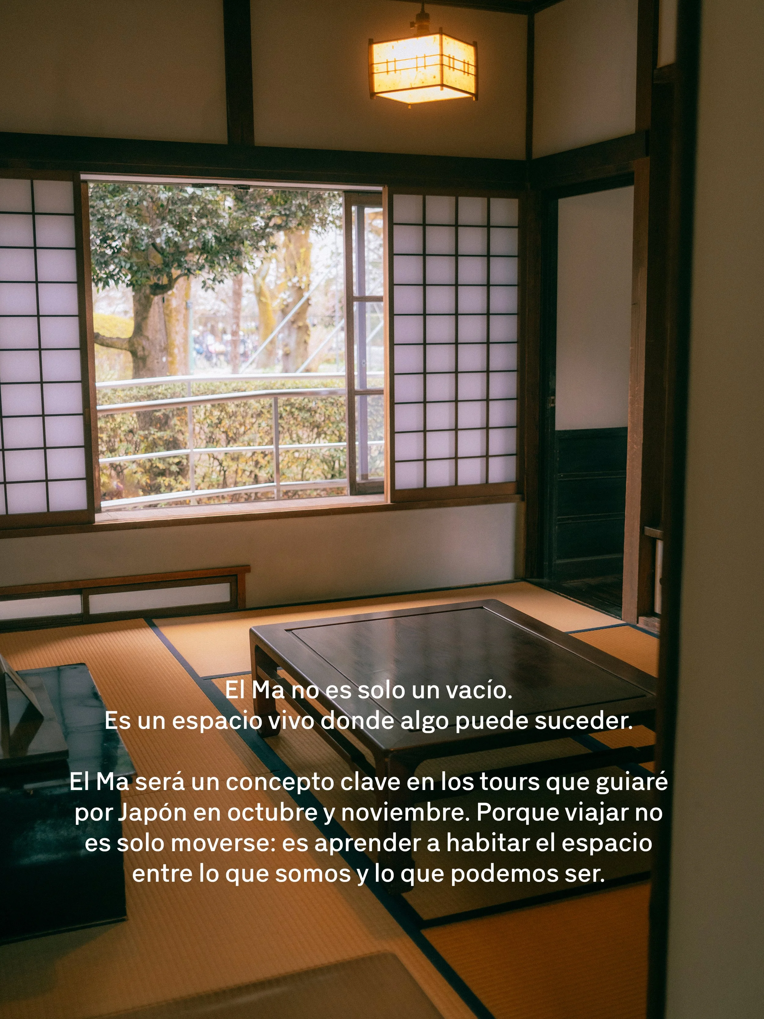 Vista de un tradicional cuarto japonés con puertas shoji de papel translúcido, tatami en el piso y una vista del exterior con árboles y una barandilla. Luz cálida en el techo