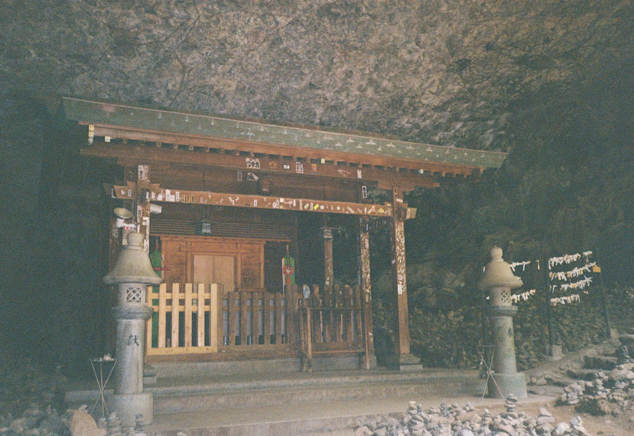 Una estructura de santuario o altar tradicional japonés, con puertas de madera decoradas y linternas】.