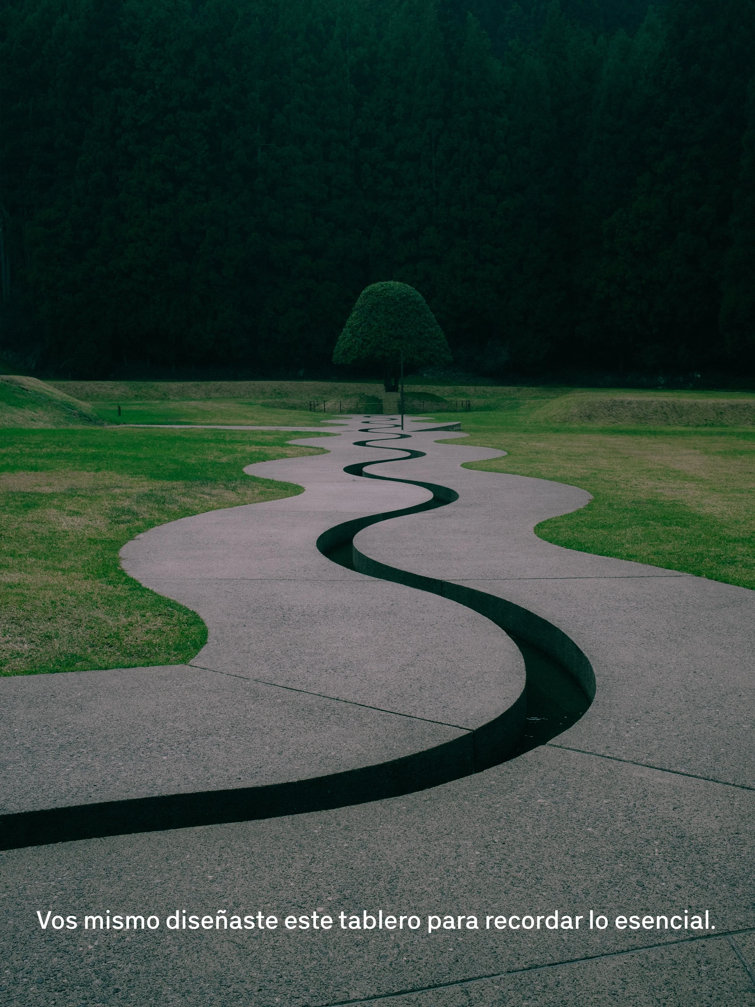 Camino curvo en el césped, con un árbol en el fondo y cabañas en la distancia, en un parque o jardín. Texto en la parte inferior que dice: 'Vos mismo diseñaste este tablero para recordar lo esencial.'