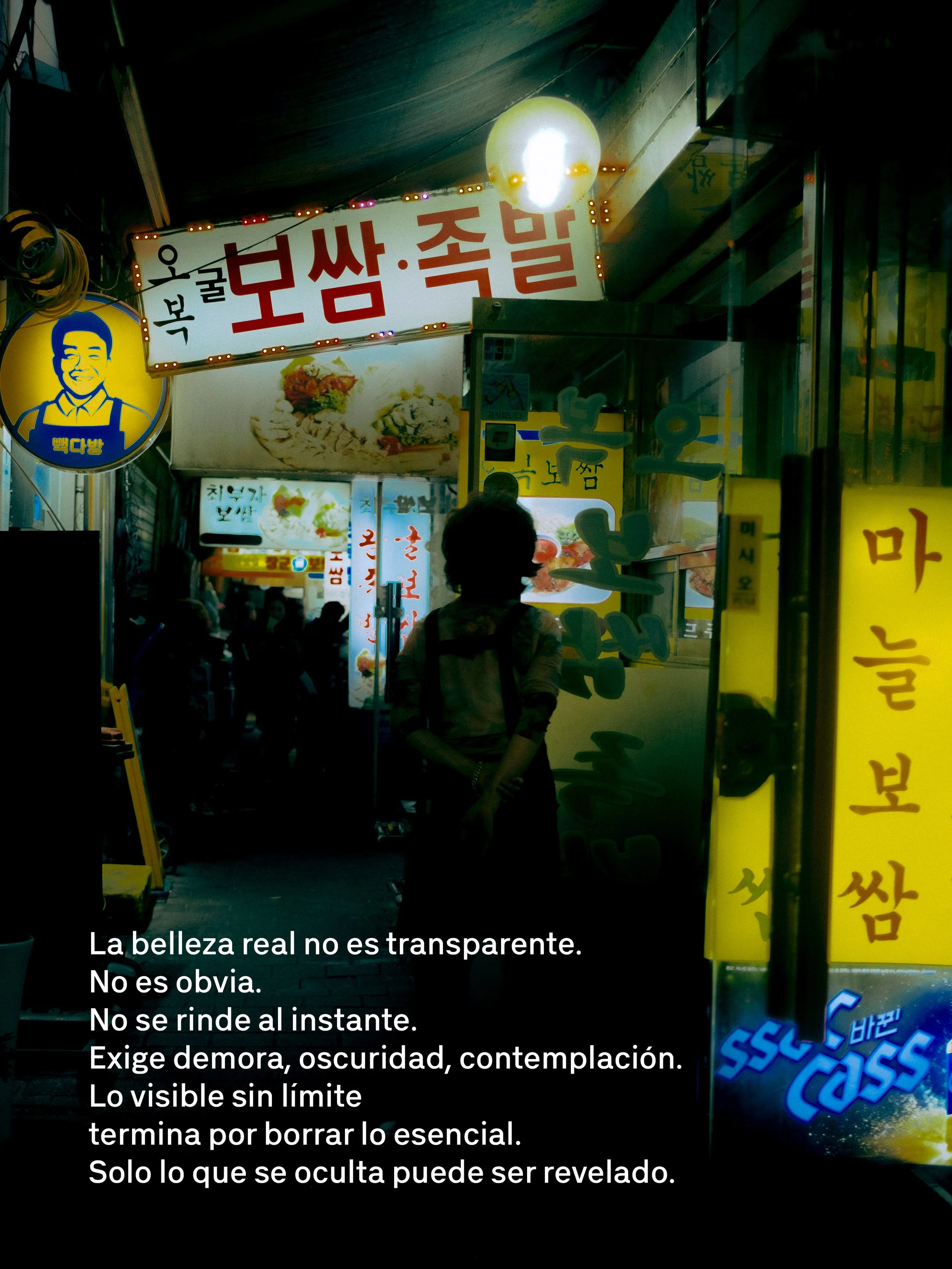 Una calle concurrida en la noche con cartel luminoso en coreano y texto en español sobre la belleza y la percepción.