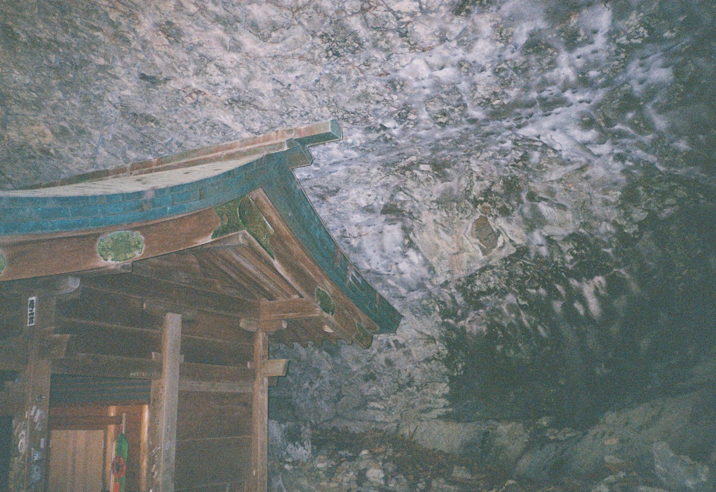 Capilla en una cueva con techo de piedra y un altar de madera