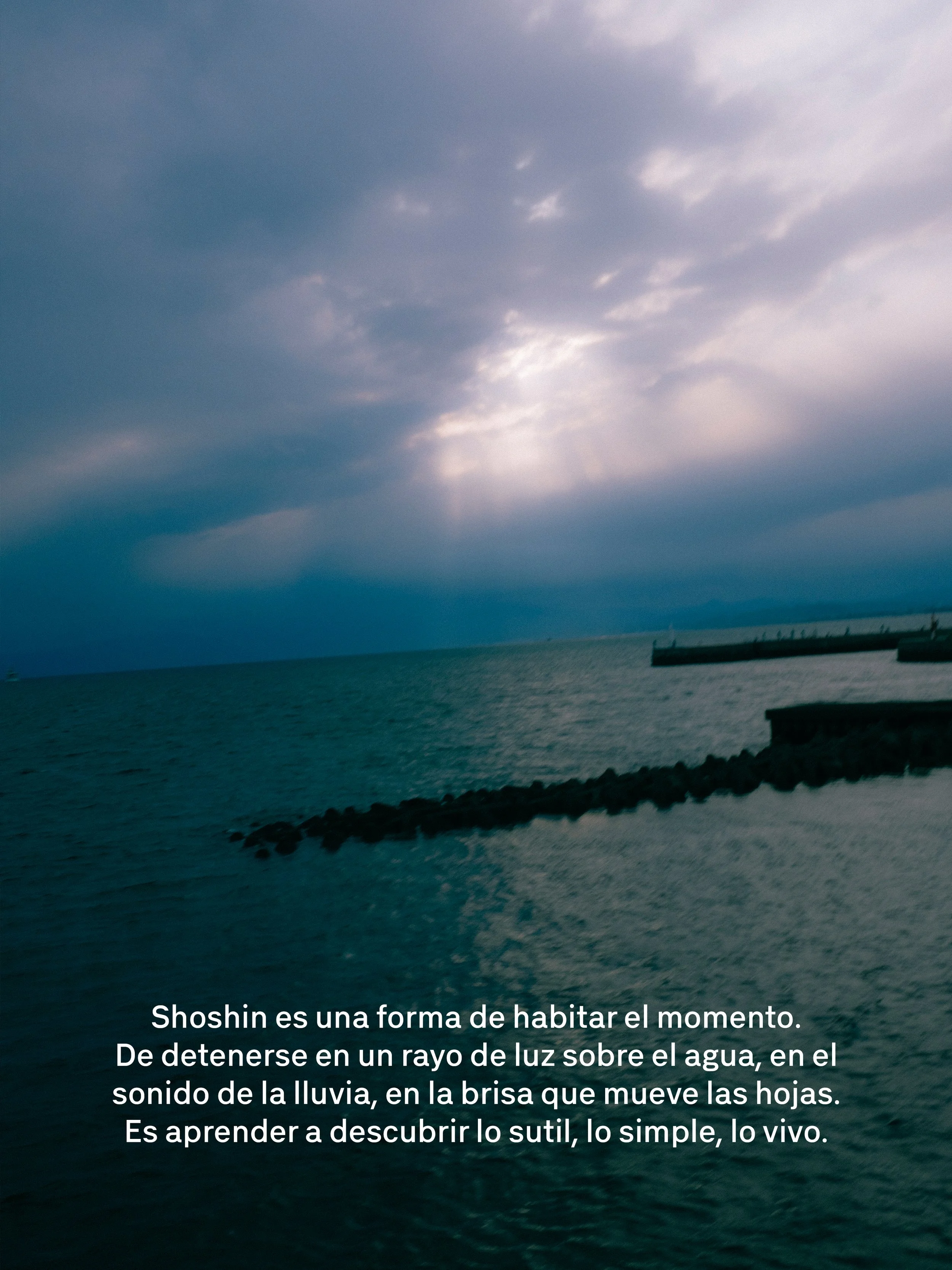 Vista del mar con cielo nublado y una boya en el agua, junto a un rompeolas.