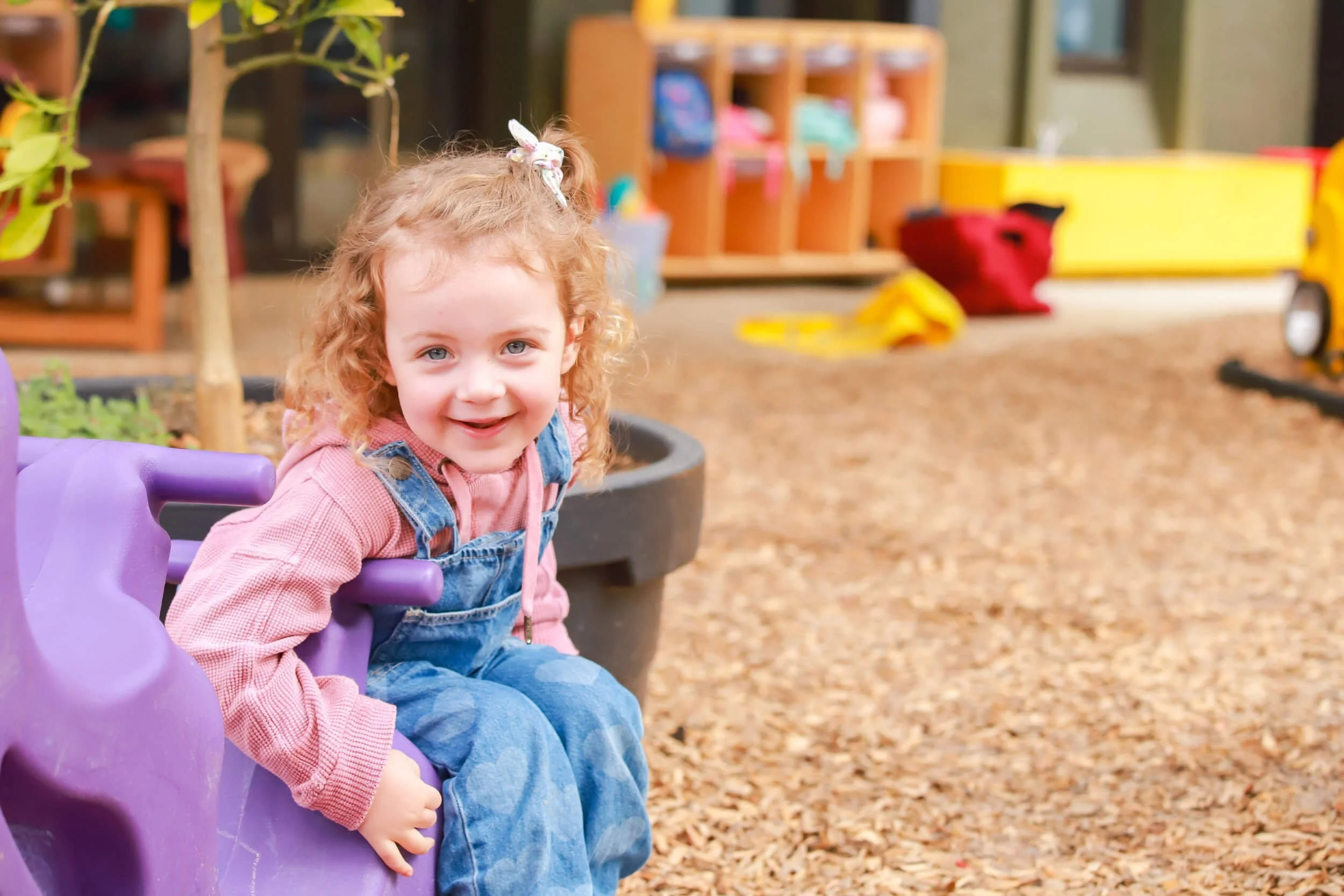Toddler on purple rocker in early childhood setting