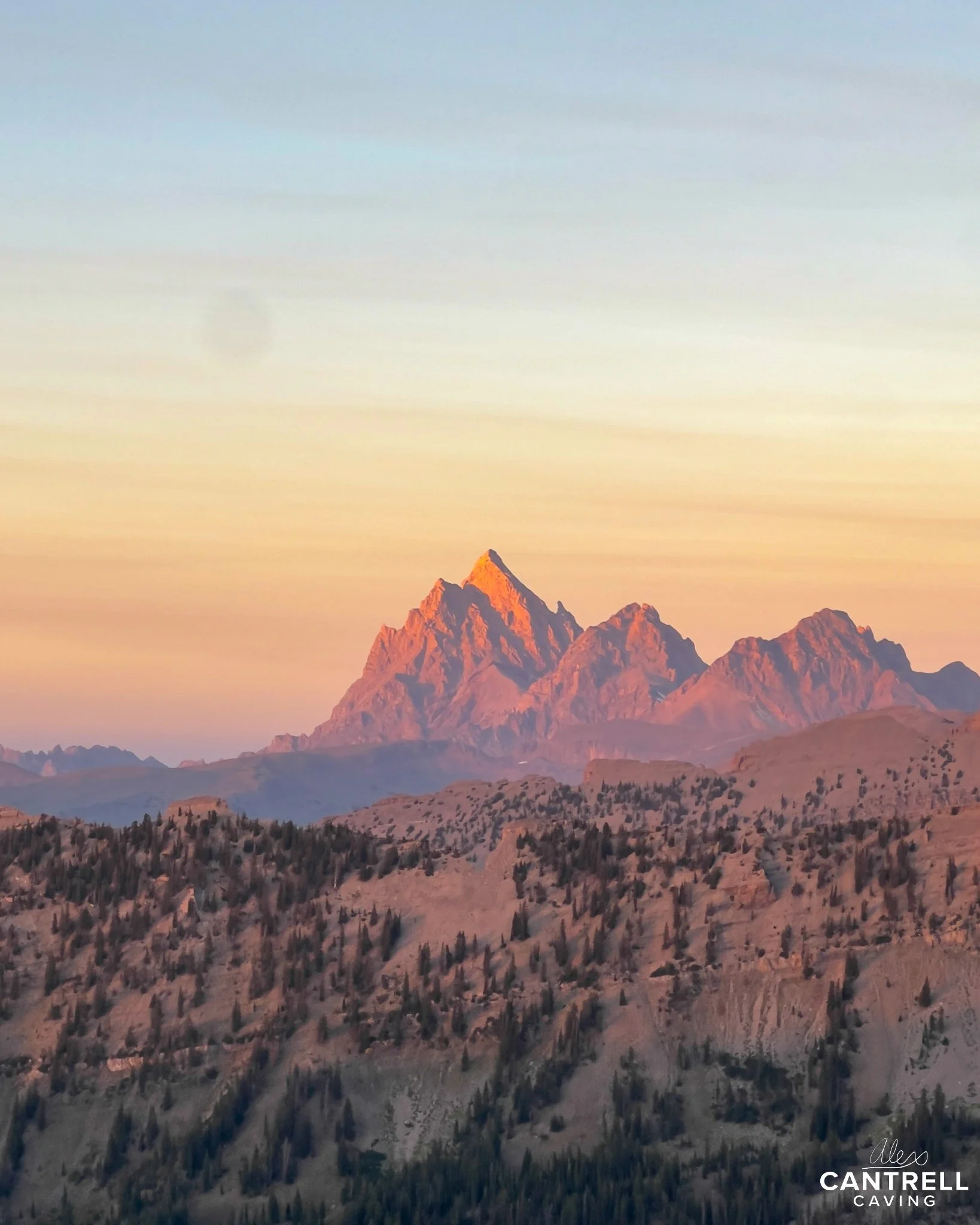 Mountain landscape featuring the Teton Range at sunset.
