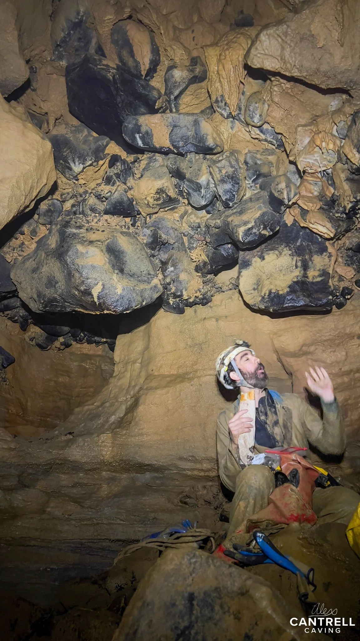 Caver exploring a rocky cave interior