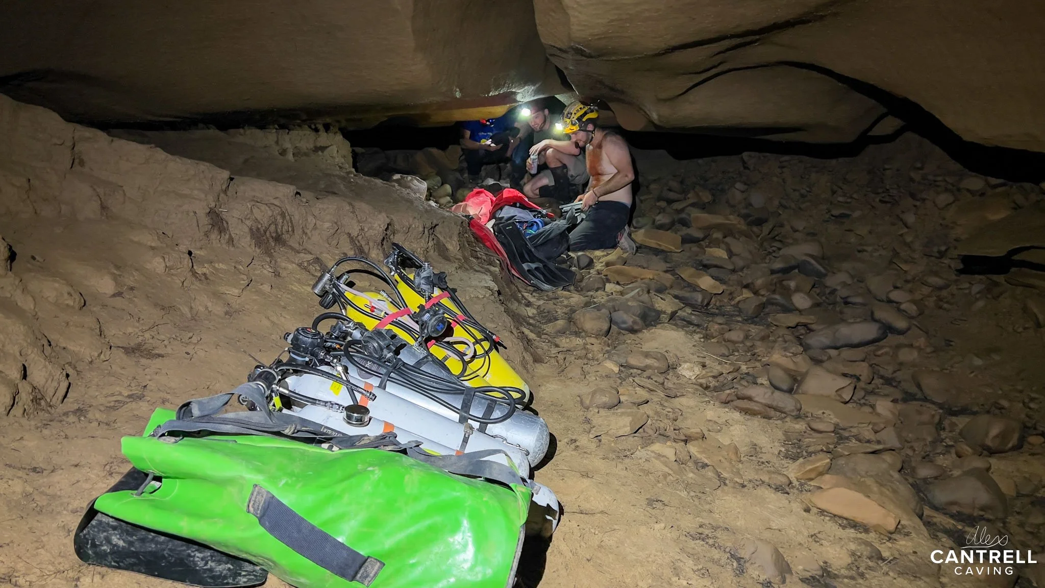 Cave explorers with caving equipment in a rocky cave