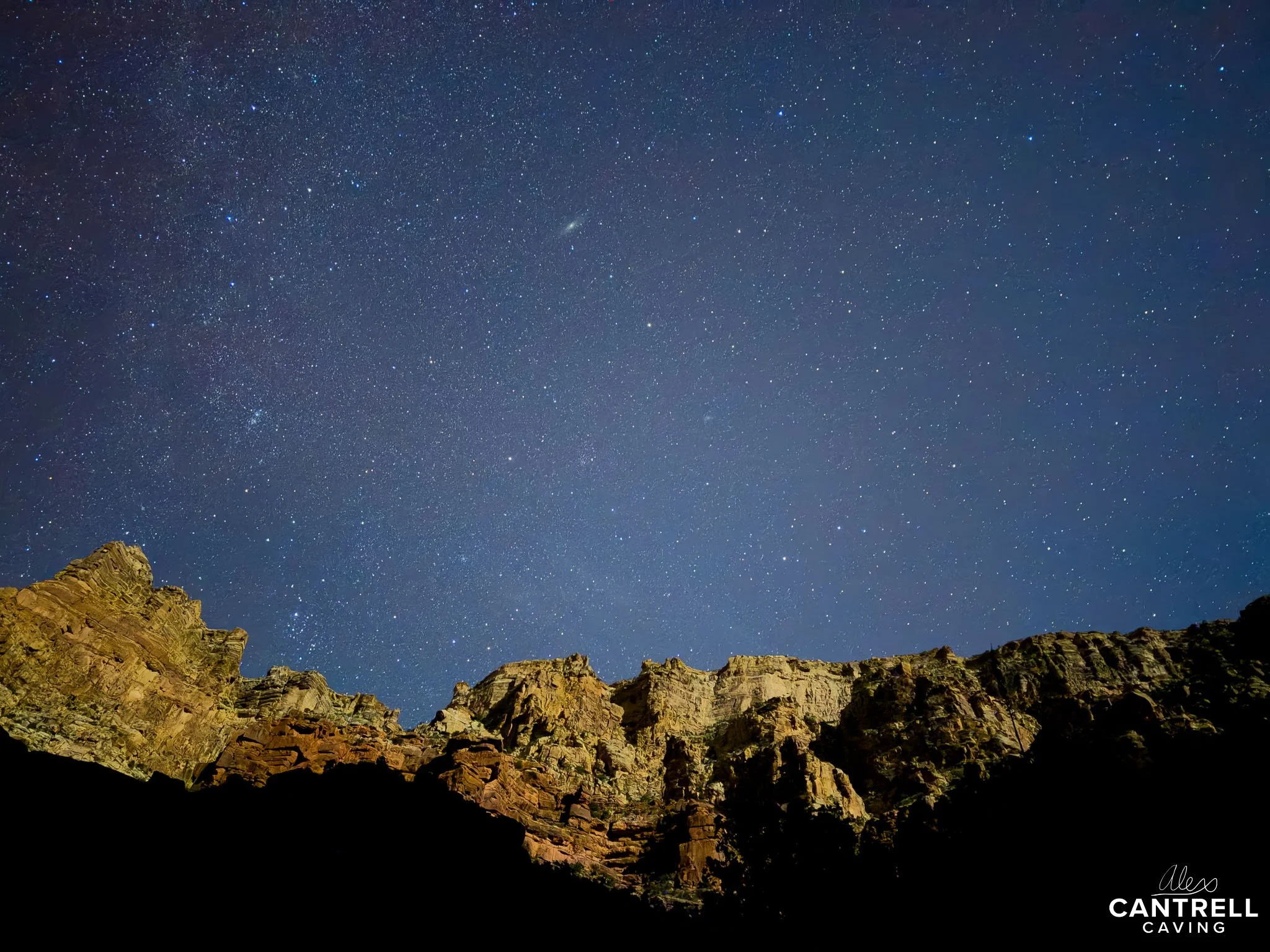 Night sky with stars over rocky cliffs