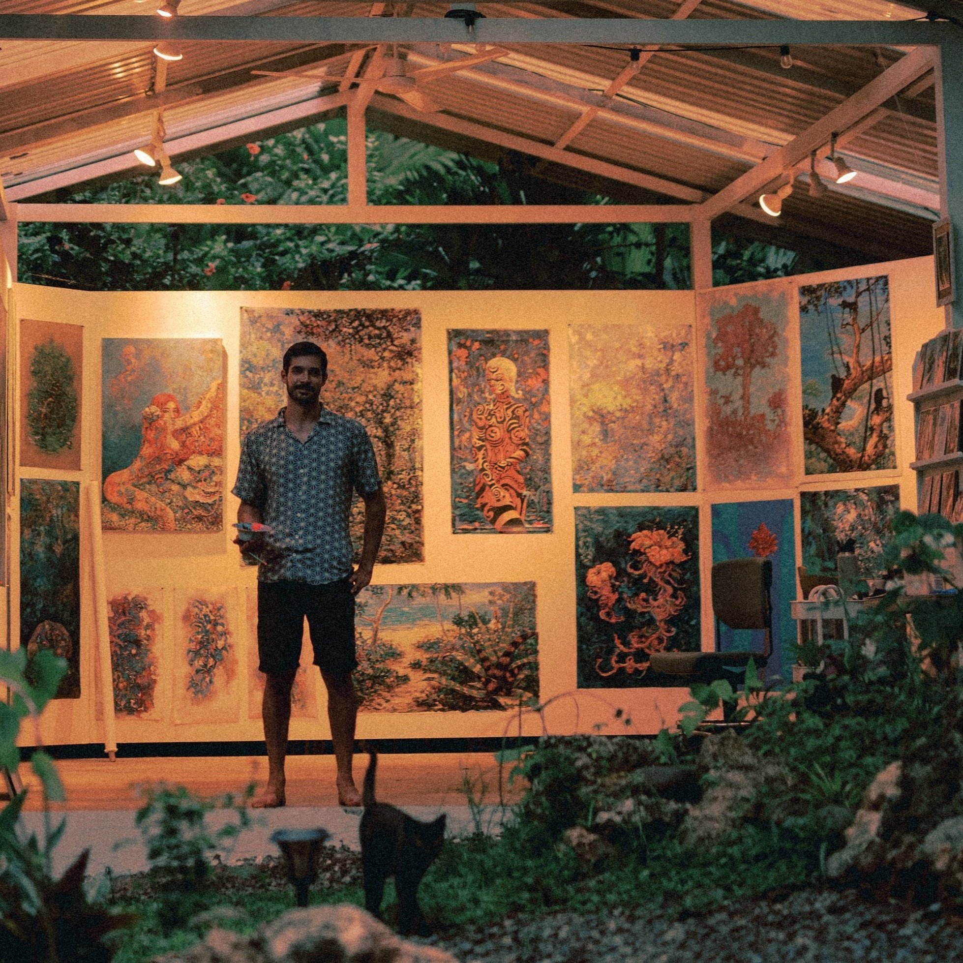 Costa Rican artist Daniel Wesson in his gallery surrounded by his tropical paintings