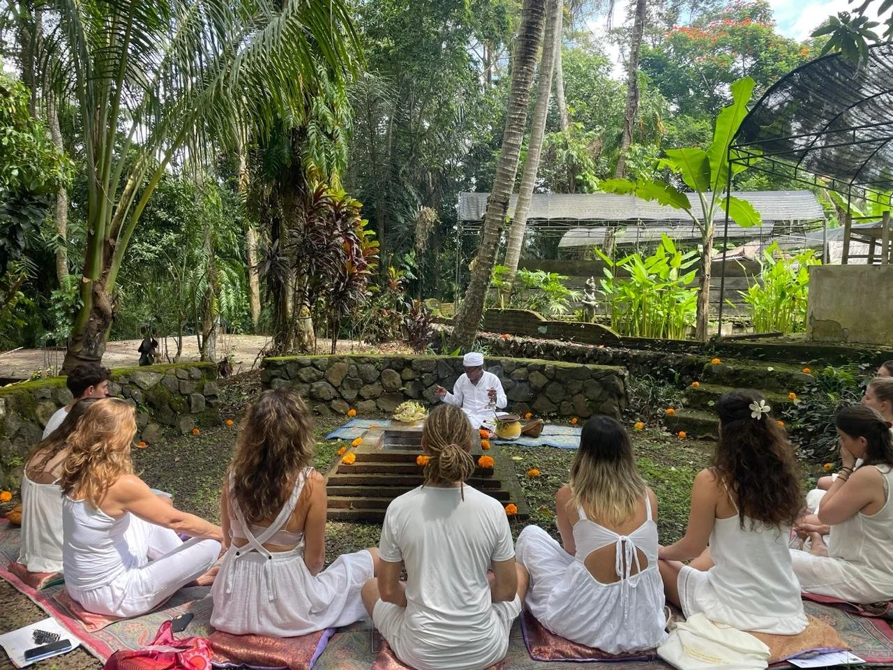 Balinese priest leading a traditional white ceremony, showcasing Balinese culture during Yoga Teacher Training