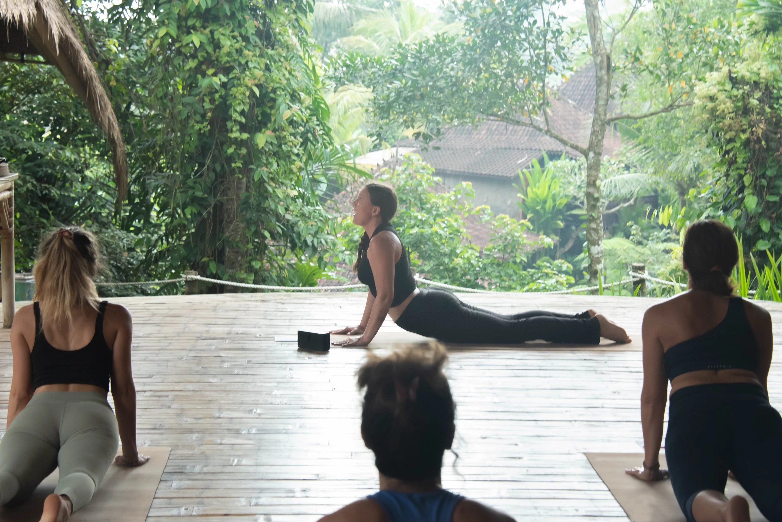 Students practising morning Hatha Yoga inside the open-air bamboo shala at SKY Yoga and Meditation in Bali