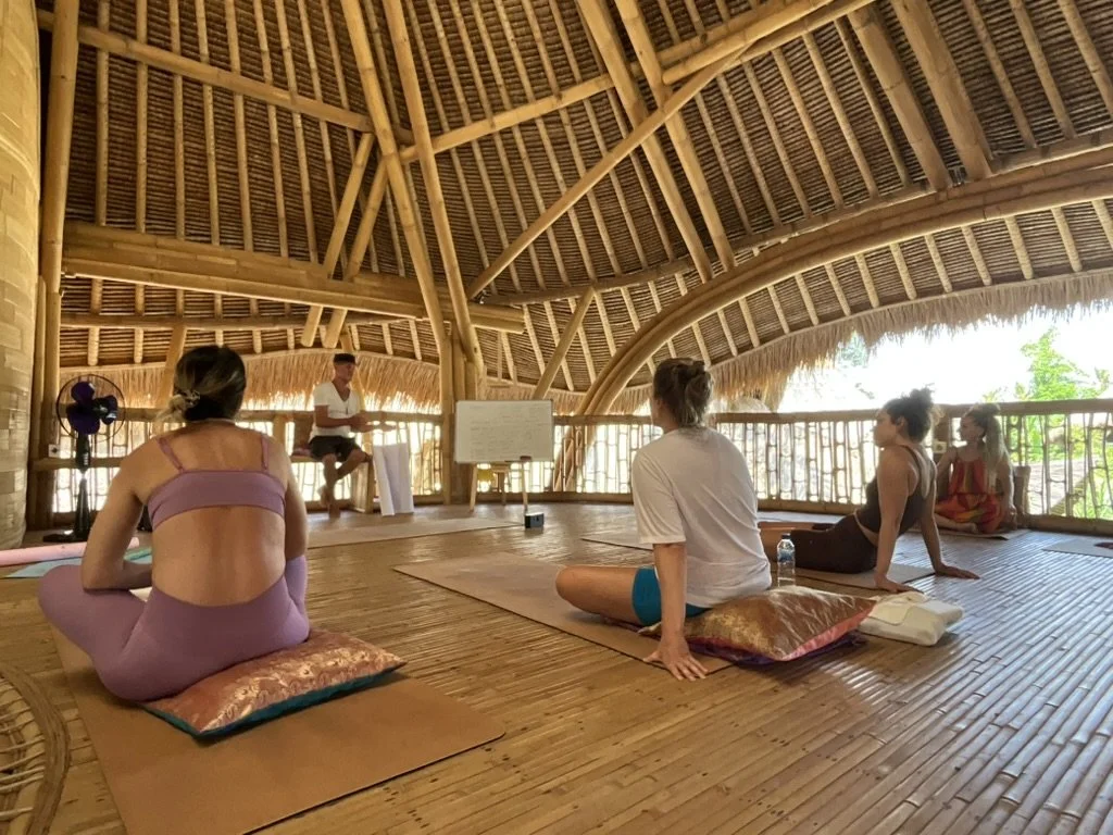 Yoga Teacher Training students studying in a bamboo shala classroom in Bali