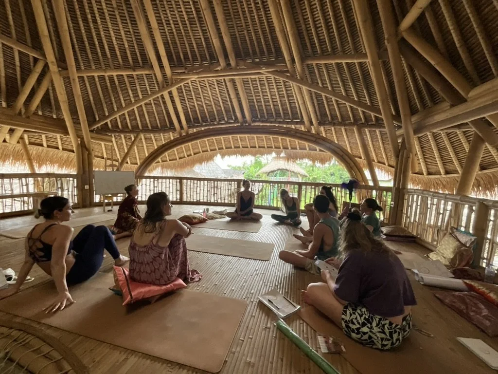 Yoga Teacher Training students learning theories together in a bamboo shala at SKY Yoga and Meditation in Bali