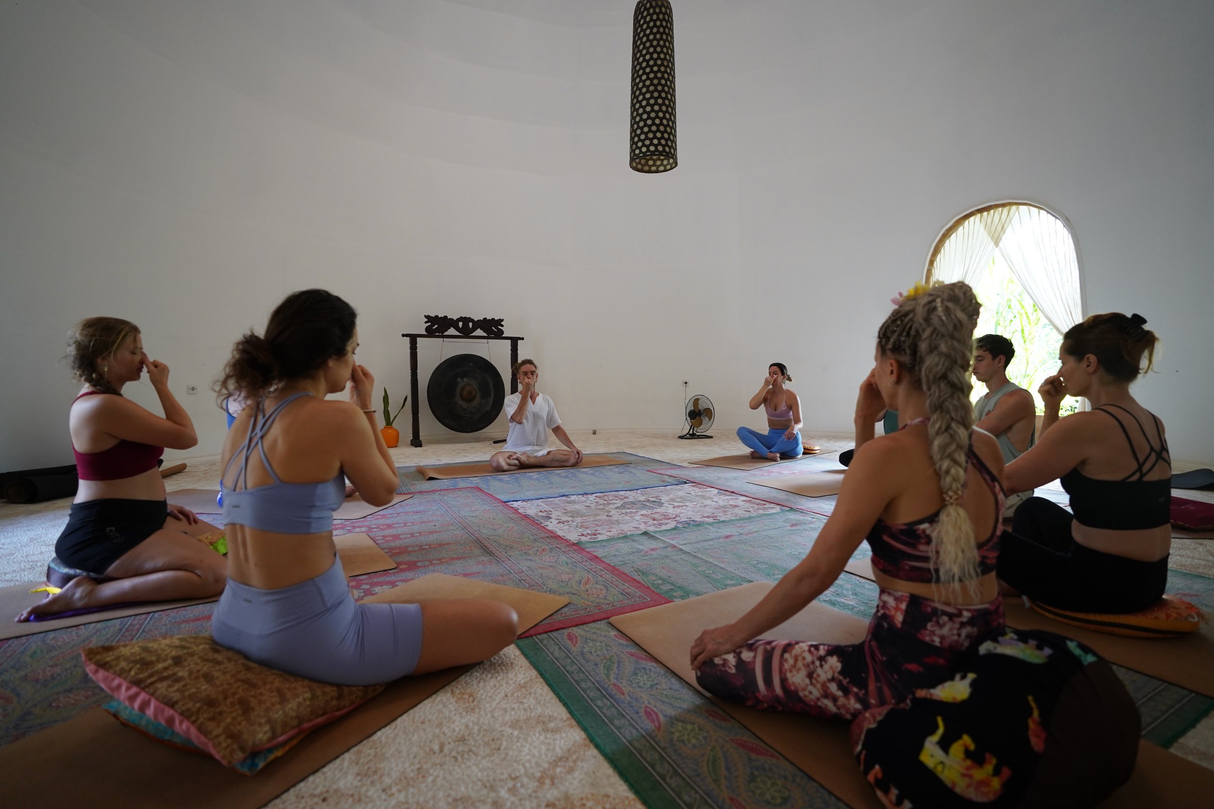 Group of students practising pranayama and meditation in SKY’s signature sound dome surrounded by bamboo and nature