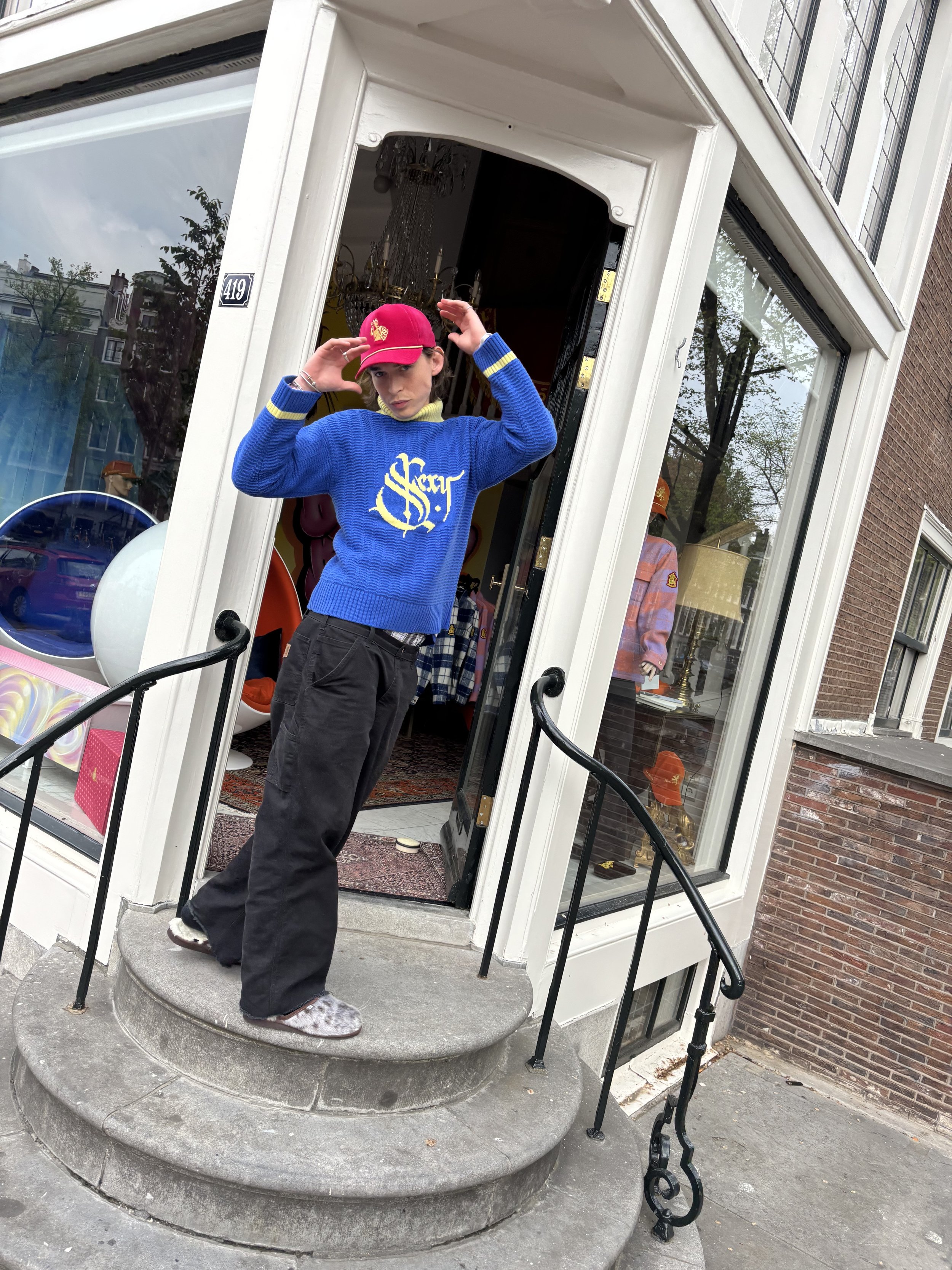 Person wearing BETTER BÅLLS knitwear outside the Amsterdam showroom at Keizersgracht 419