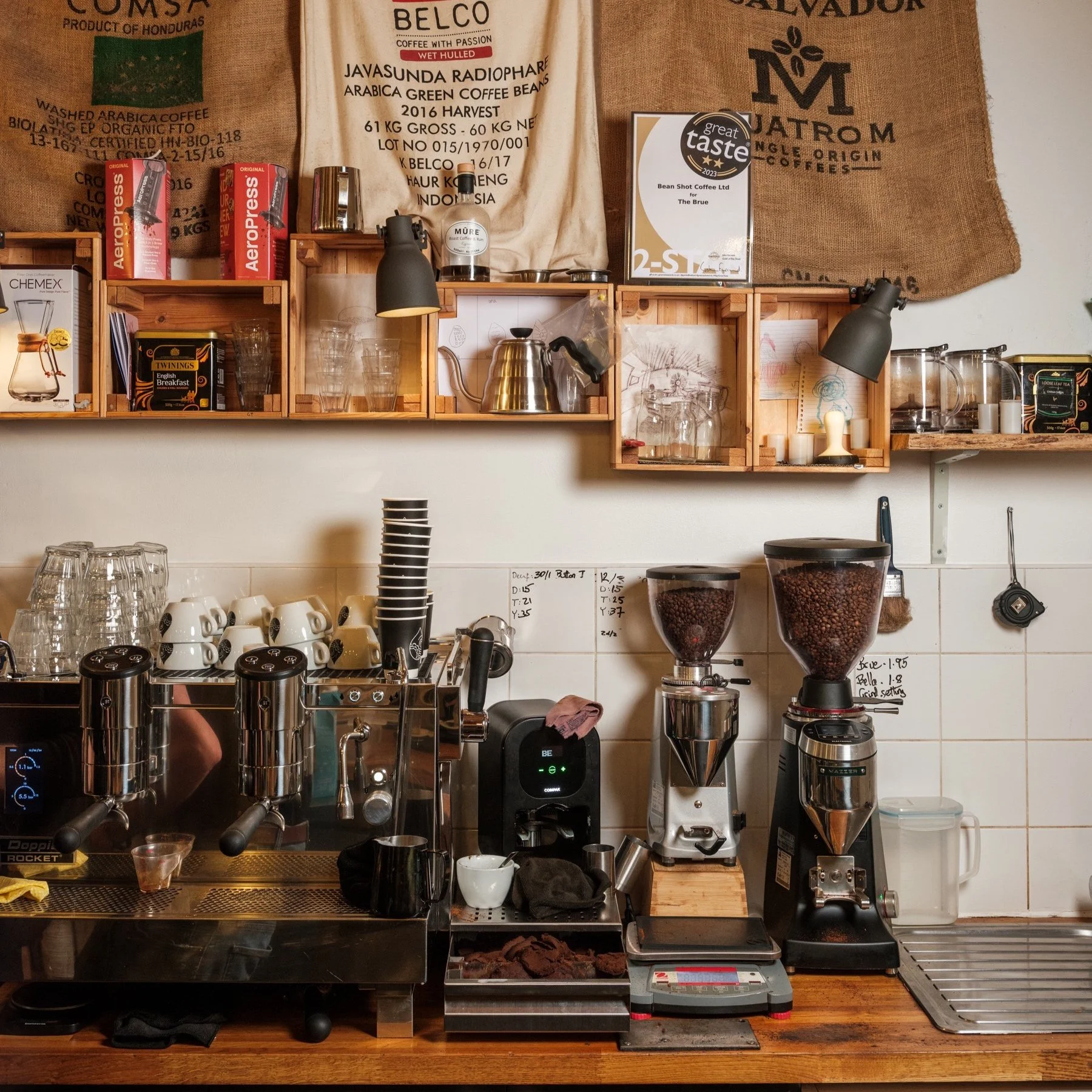 Coffee machine in coffee shop with cups, coffee beans, wooden crates and coffee sacks