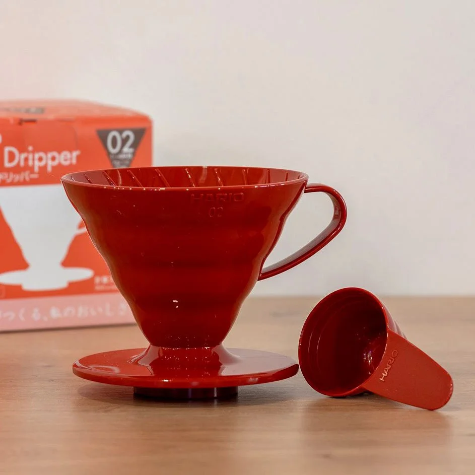 Red Hario V60 (02) on wooden counter with packaging in background