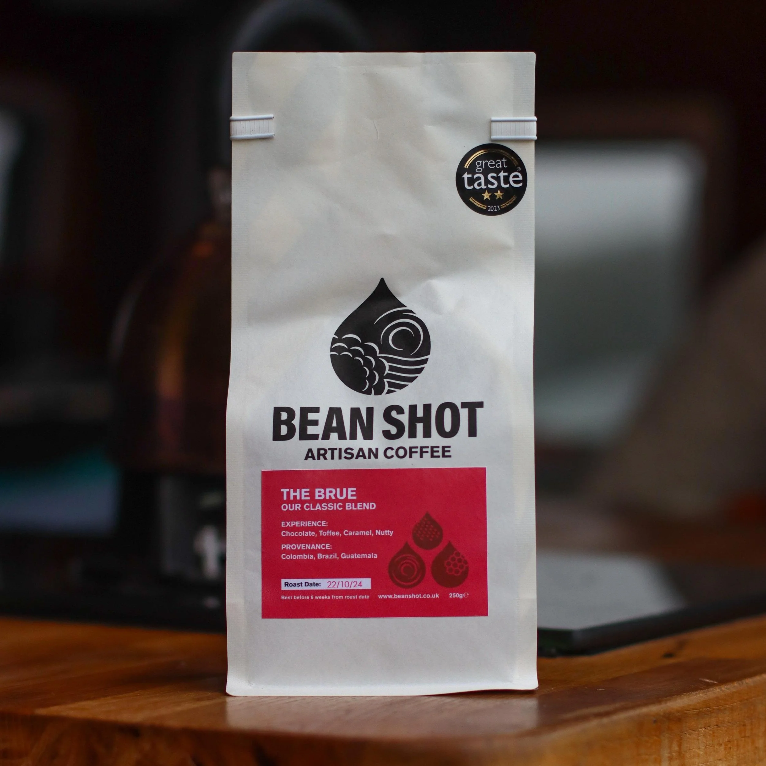 The Brue ethical and freshly roasted coffee beans in bag on wooden counter