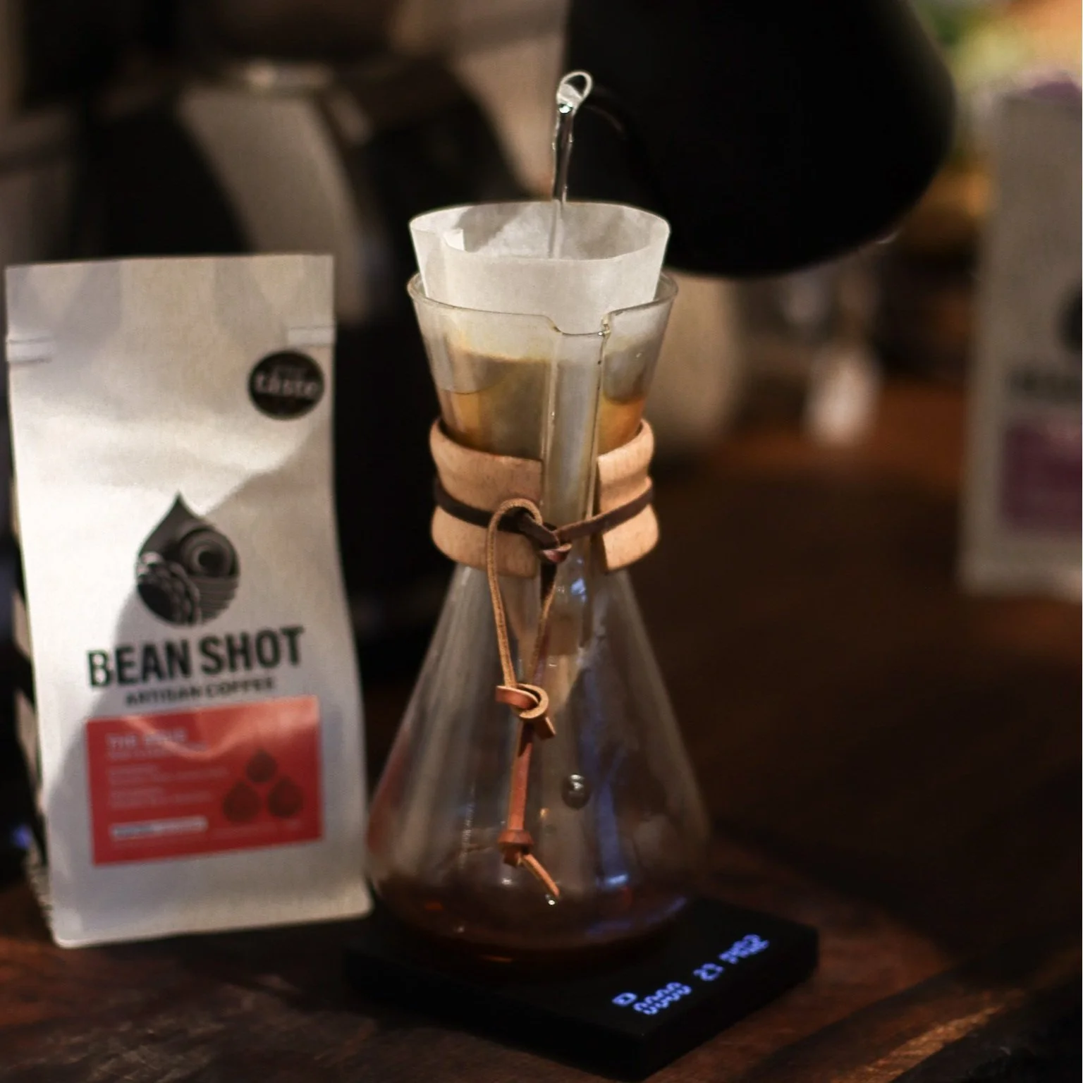 Chemex 3 cup pour over coffee shown in kitchen on scales with filter and bag of bean shot coffee