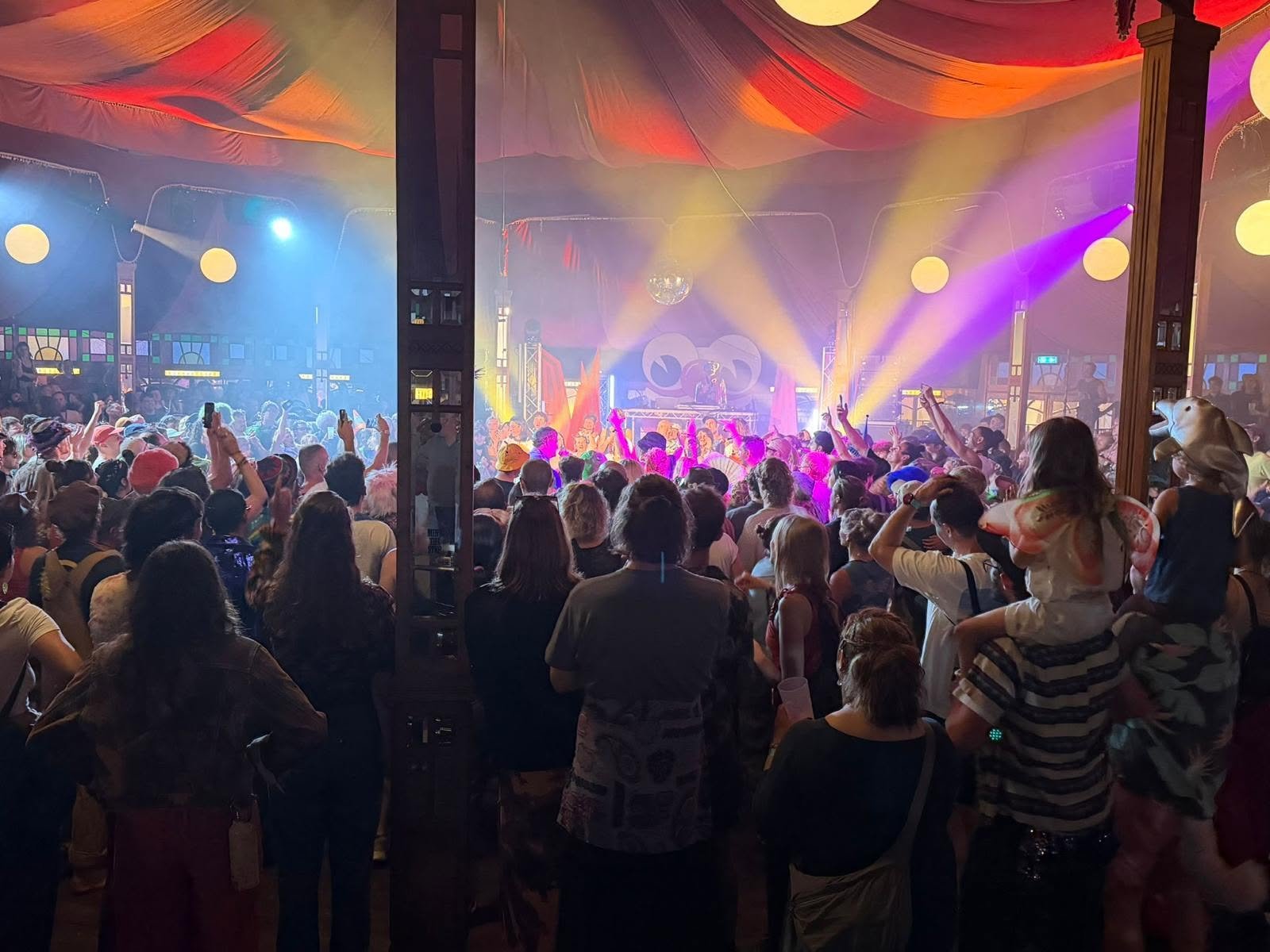Families and festival goers enjoying the acts in the Spiegeltent at Shambala 2026