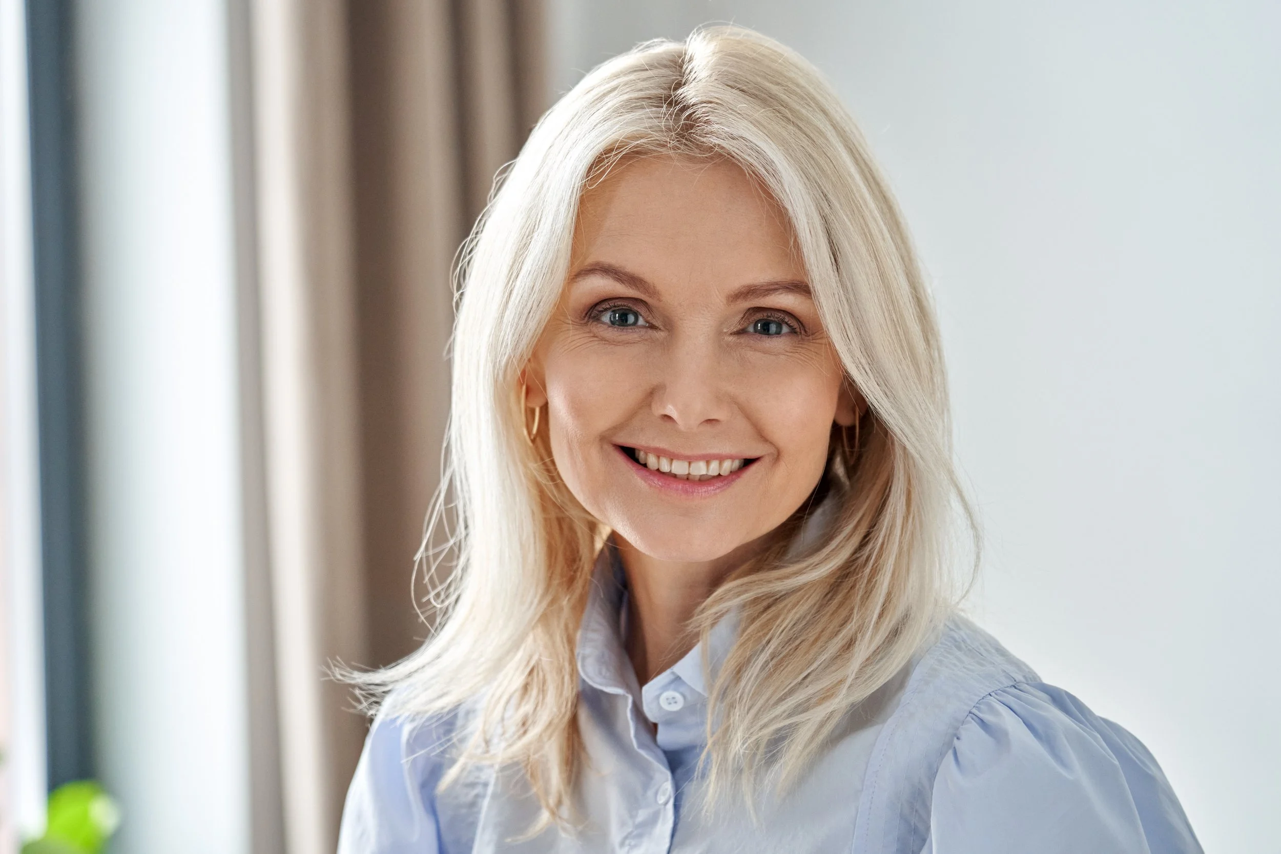 smiling-woman-in-blue-shirt-posing-indoors-2026-03-18-16-02-53-utc.jpg