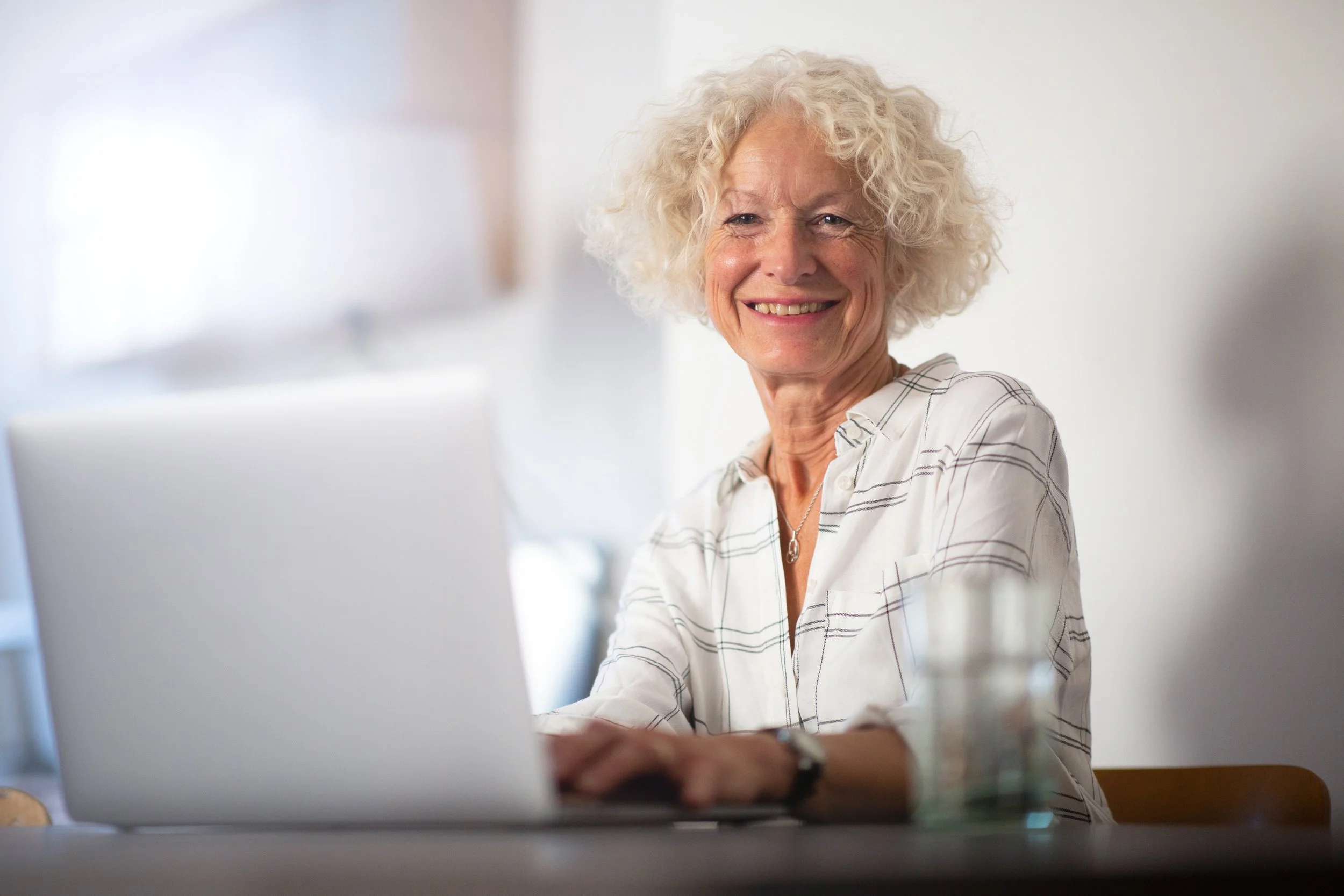 smiling-senior-woman-uses-laptop-at-table-2026-03-09-23-12-50-utc.jpg