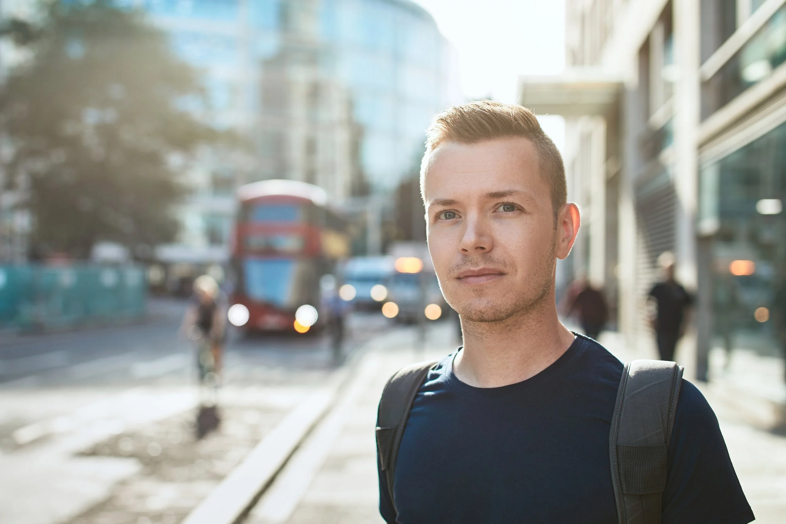 portrait-of-young-man-against-city-street-with-bus-2026-03-18-20-49-42-utc.jpg