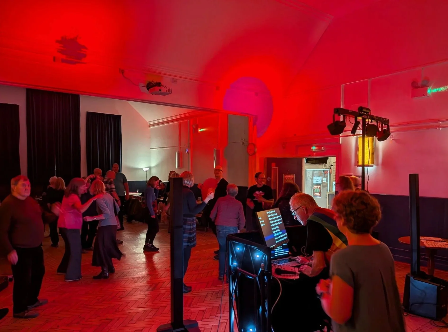 People dancing in a room with colourful disco lighting