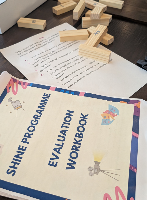 Paper booklet with the title ' Shine Programme - Evaluation workbook'