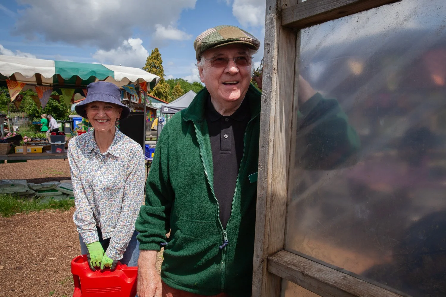 A woman and a man smiling on a sunny day in Redcatch Community Garden