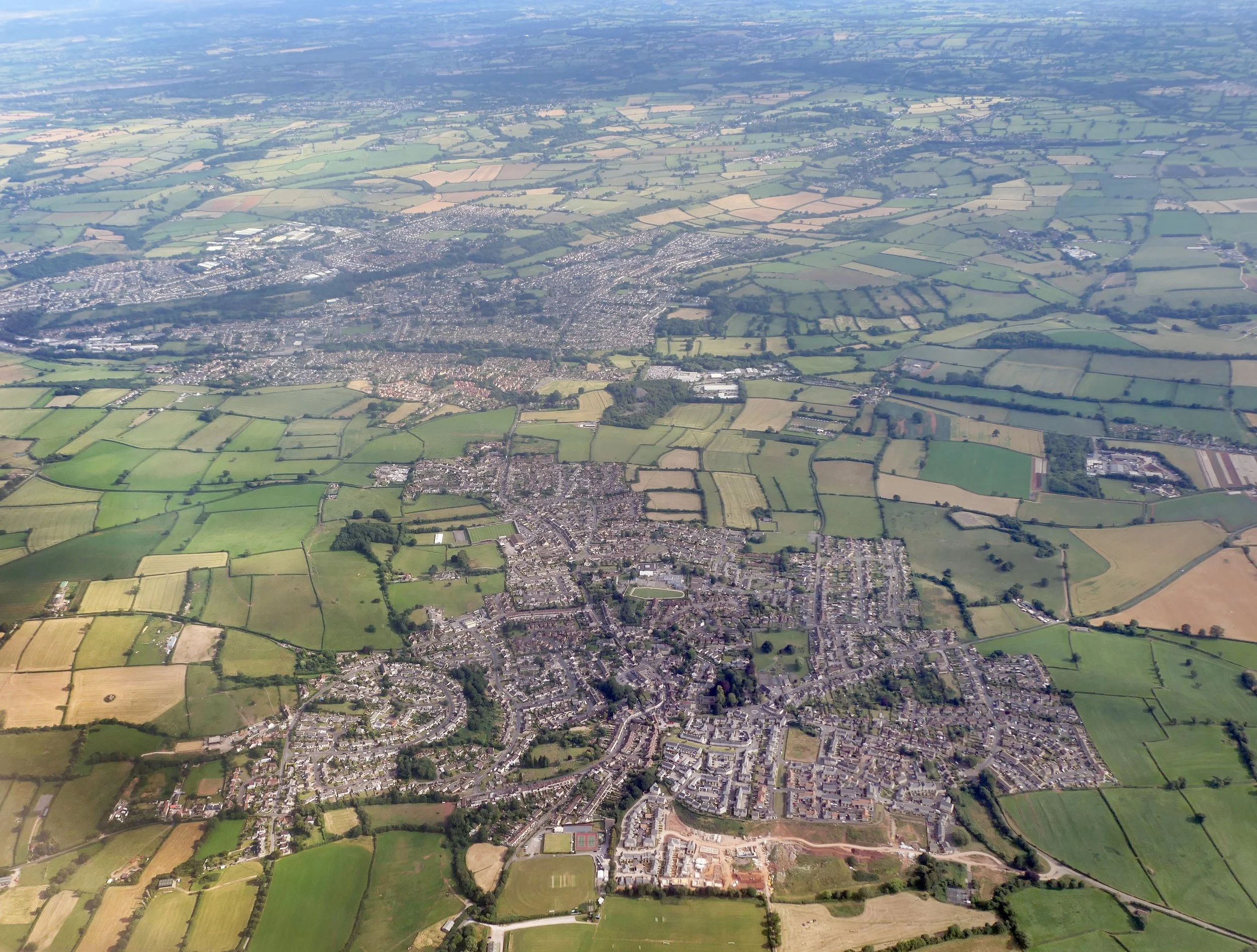 Aerial view of the Somer Valley, with a mix of houses, green fields, roads and countryside