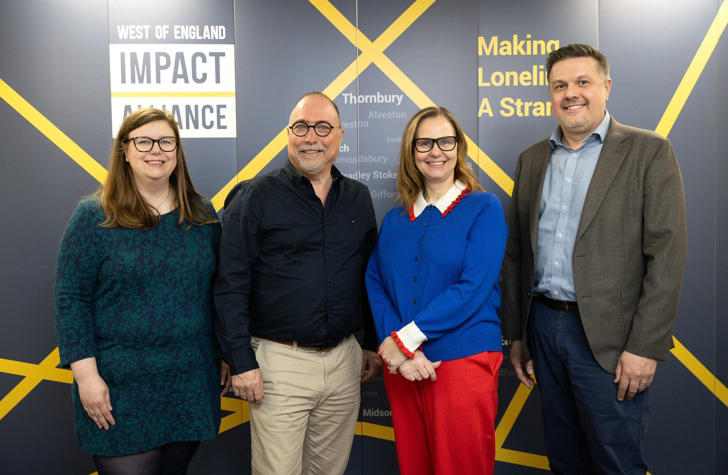Sophie Moysey, David Williams, Helen Godwin and Simon Wales in front of a banner for the Impact Alliance