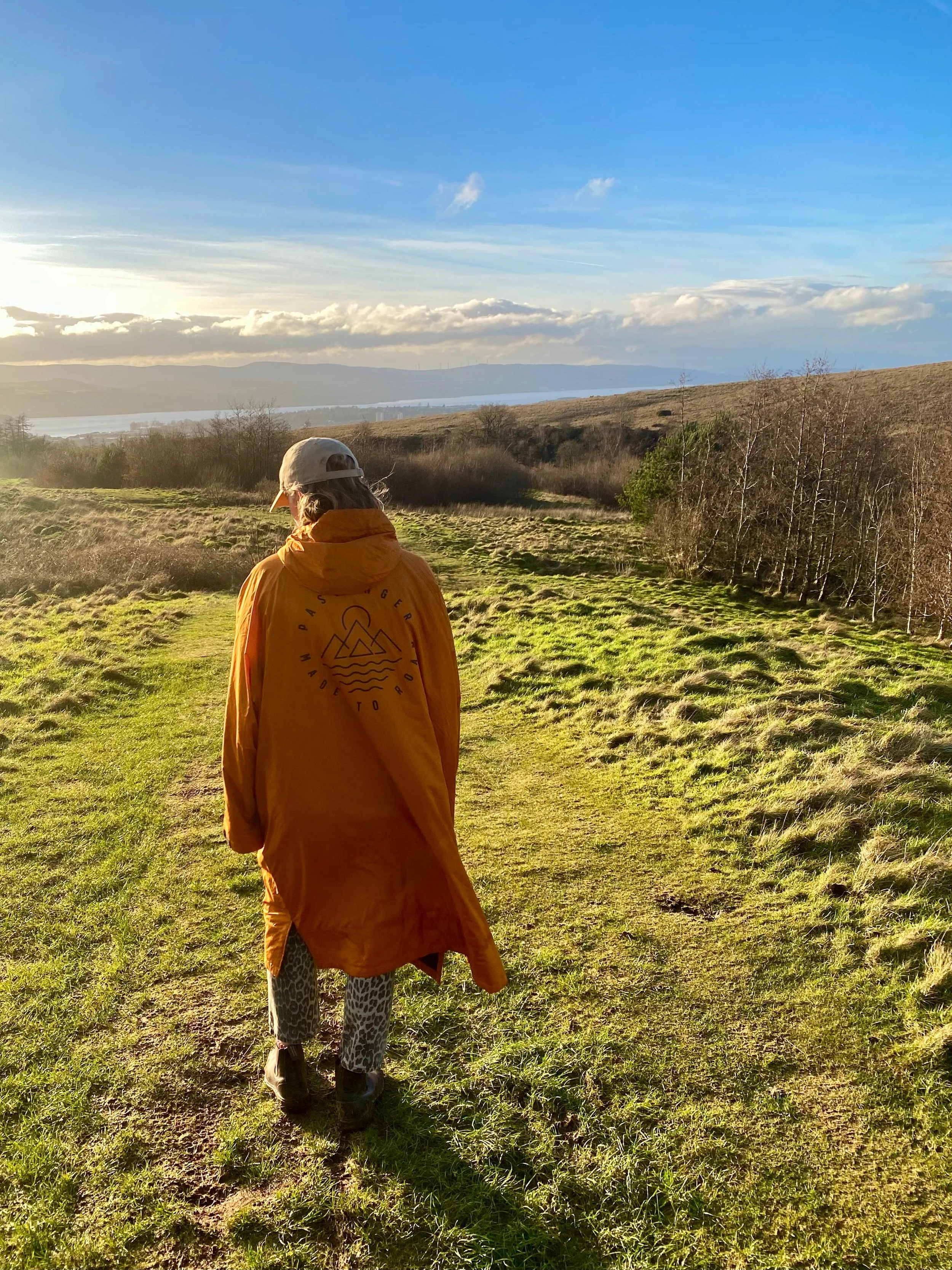 Woman walking through countryside on sunny day